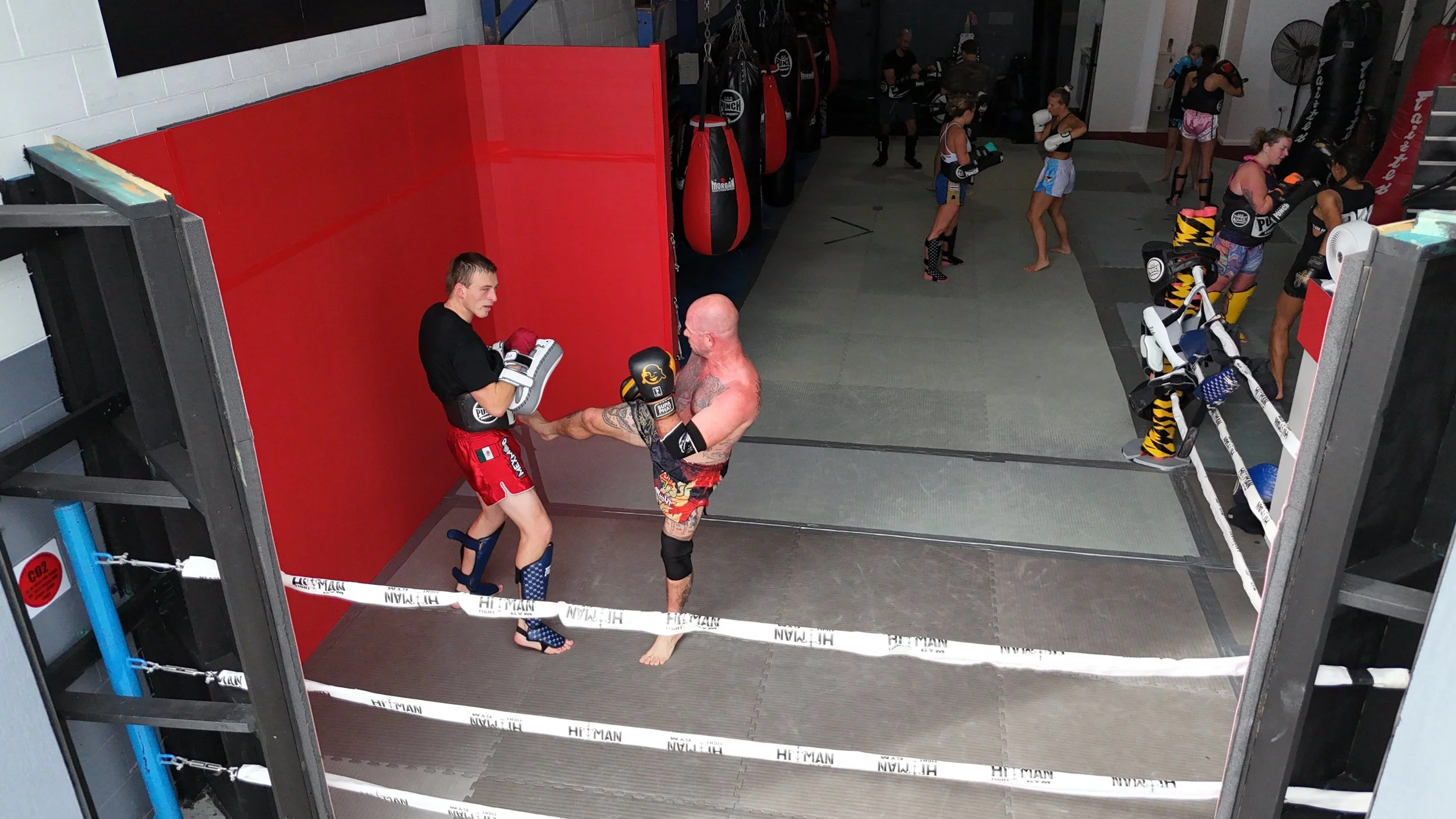 Muay Thai pad work in the ring: a kick into Thai pads at DM Muay Thai & Fitness, Tweed Heads