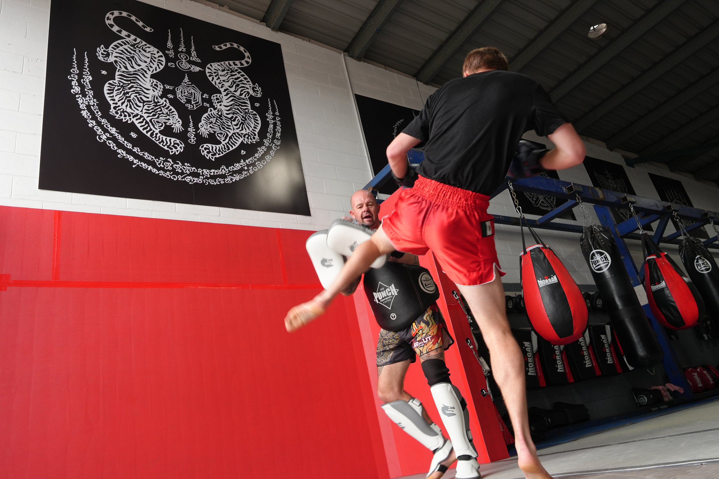 Flying knee on the pads in the ring at DM Muay Thai & Fitness, Tweed Heads