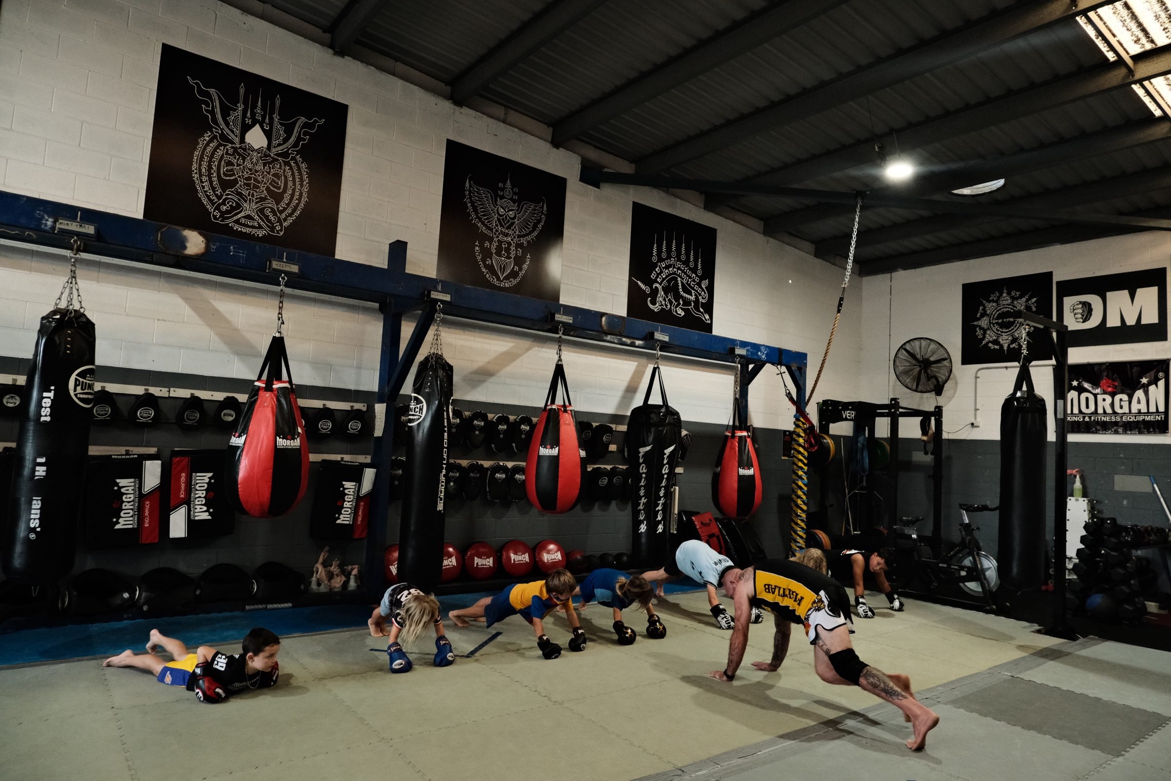 Kids doing push-ups in a line during the fitness part of a Muay Thai kids class in Tweed Heads
