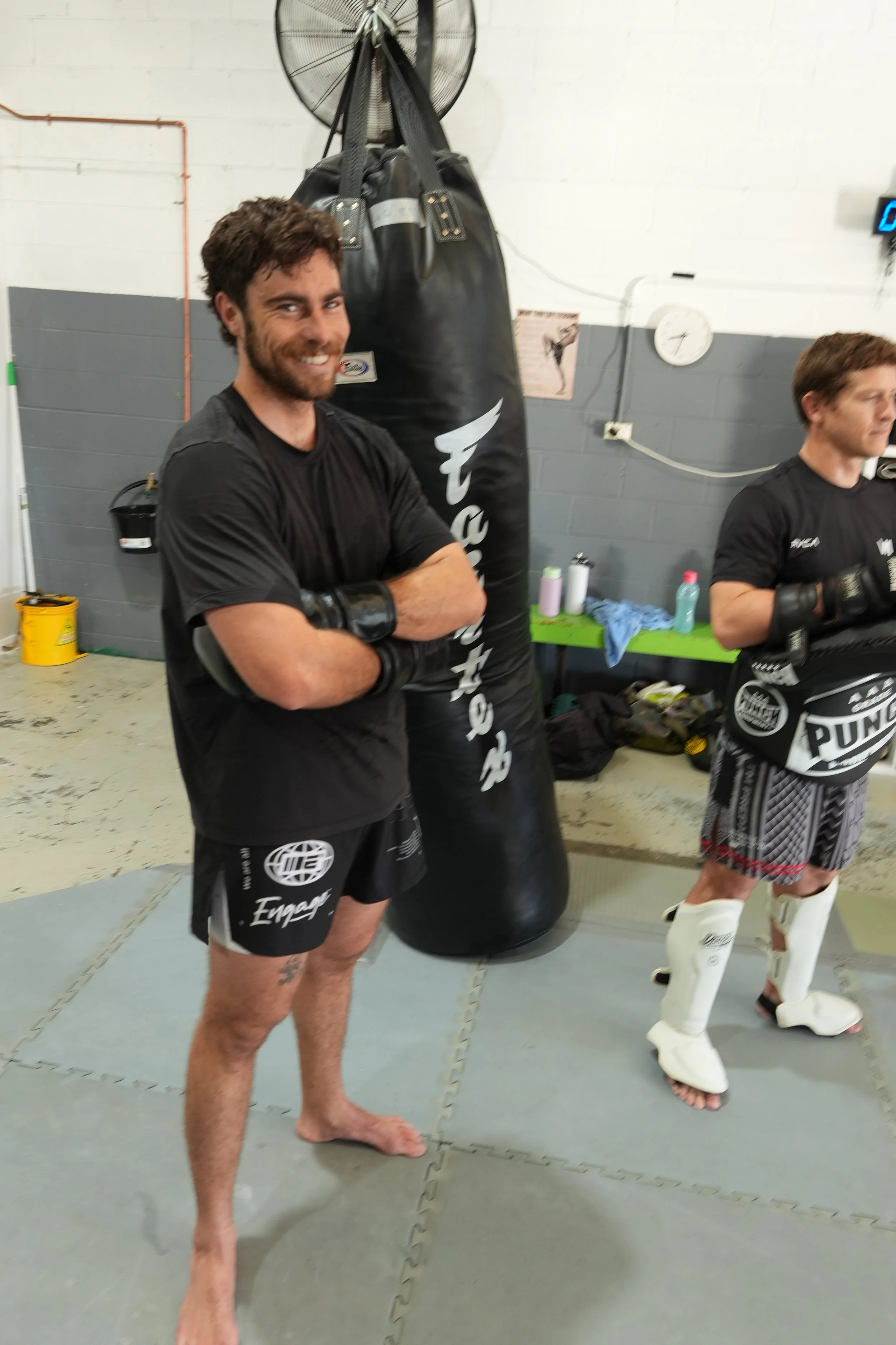 Smiling member in gloves after a Muay HIIT session at DM Muay Thai & Fitness