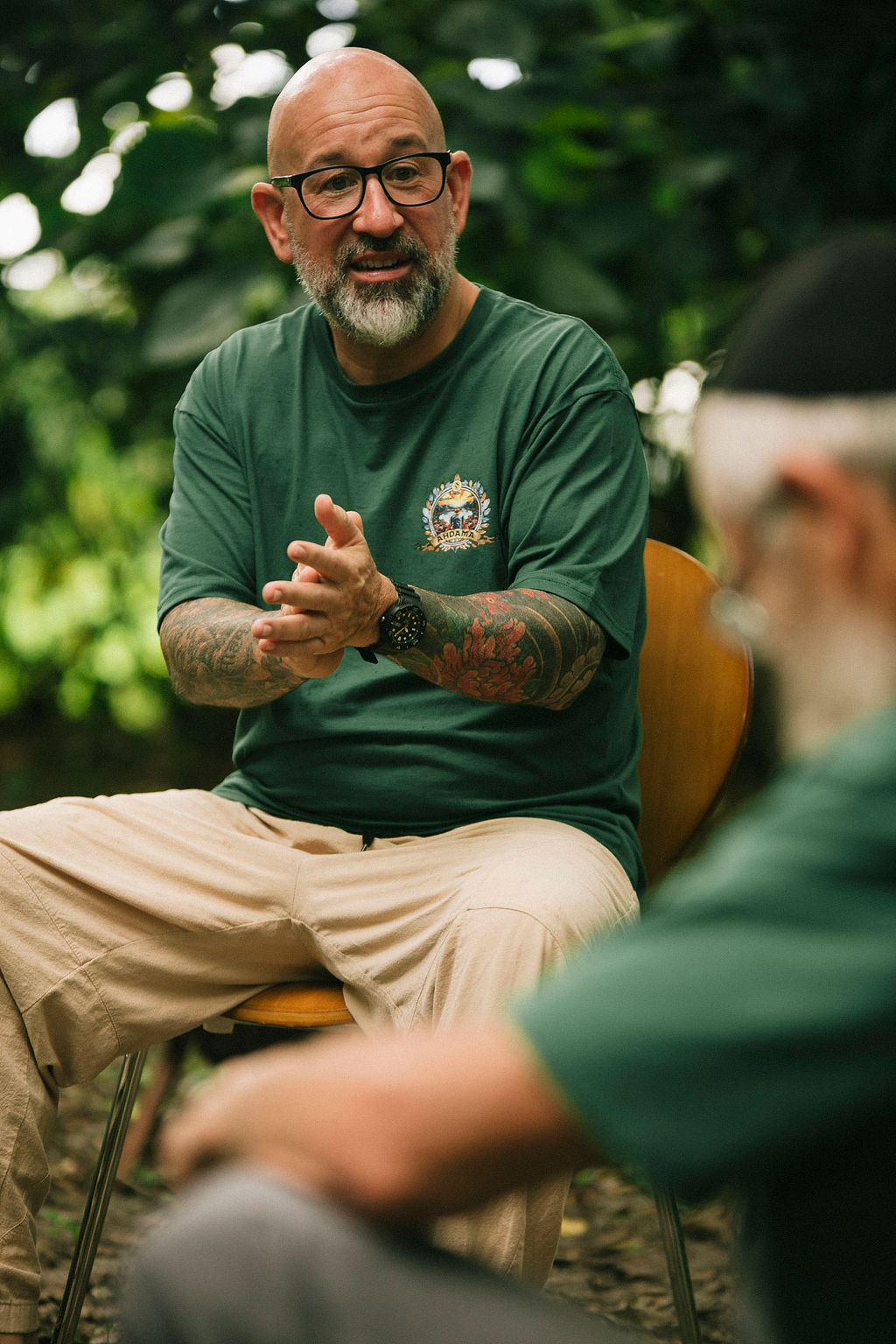 Omar Pinto speaking to a group in an open-air retreat setting.