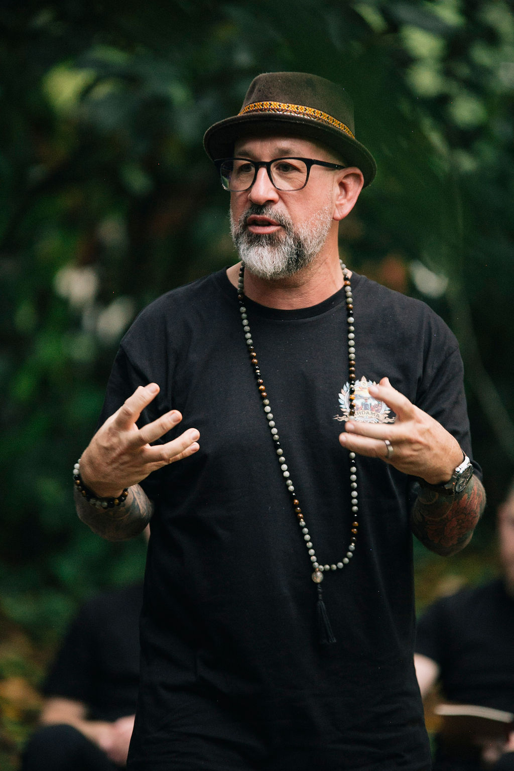 Omar Pinto, men's coach and creator of The Twelve Men, speaking during an outdoor group retreat.