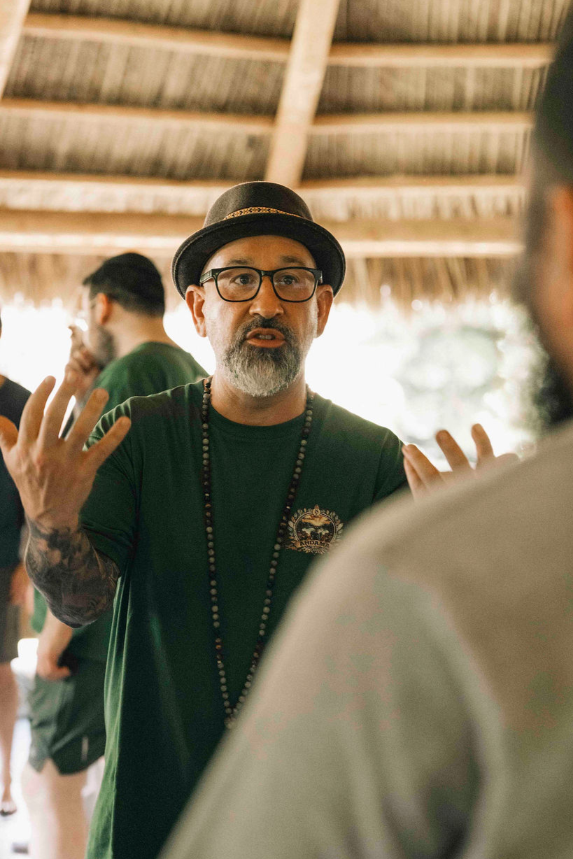 Omar Pinto, men's coach and creator of The Twelve Men, speaking during an outdoor group retreat.