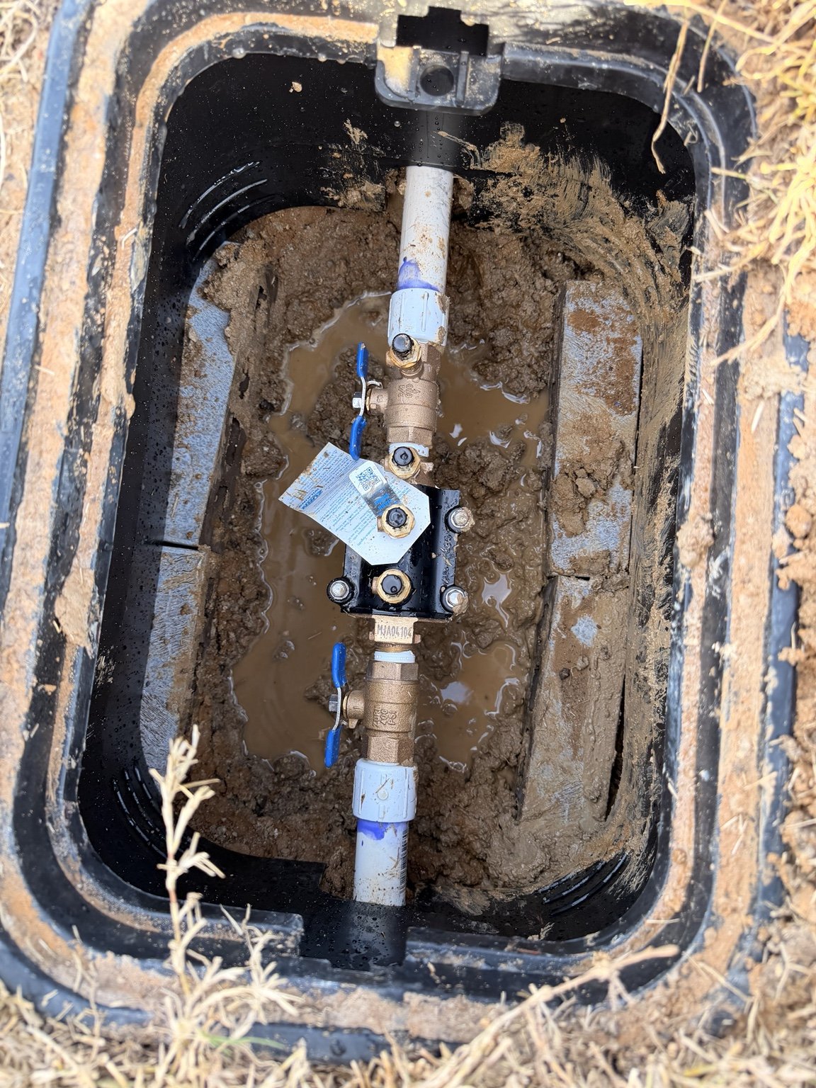 Irrigation system detail — valves and piping inside an underground service box.
