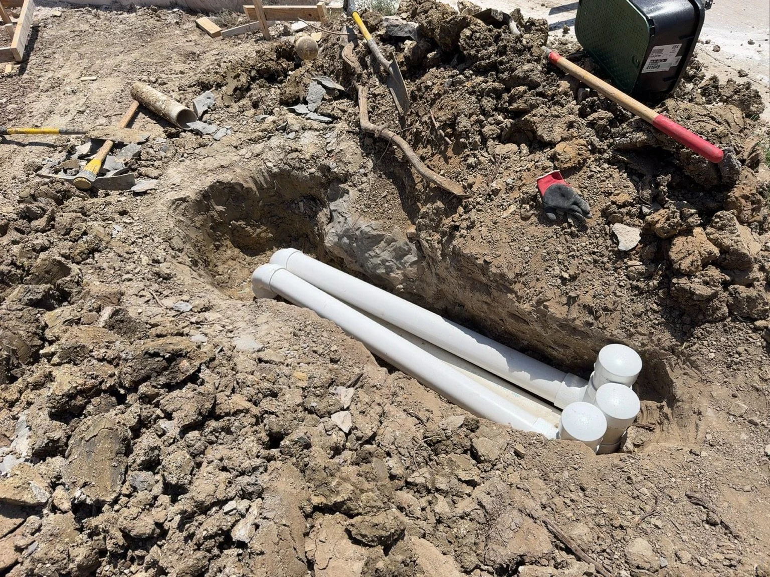 Underground installation — PVC pipe crossings and sleeves during site construction.