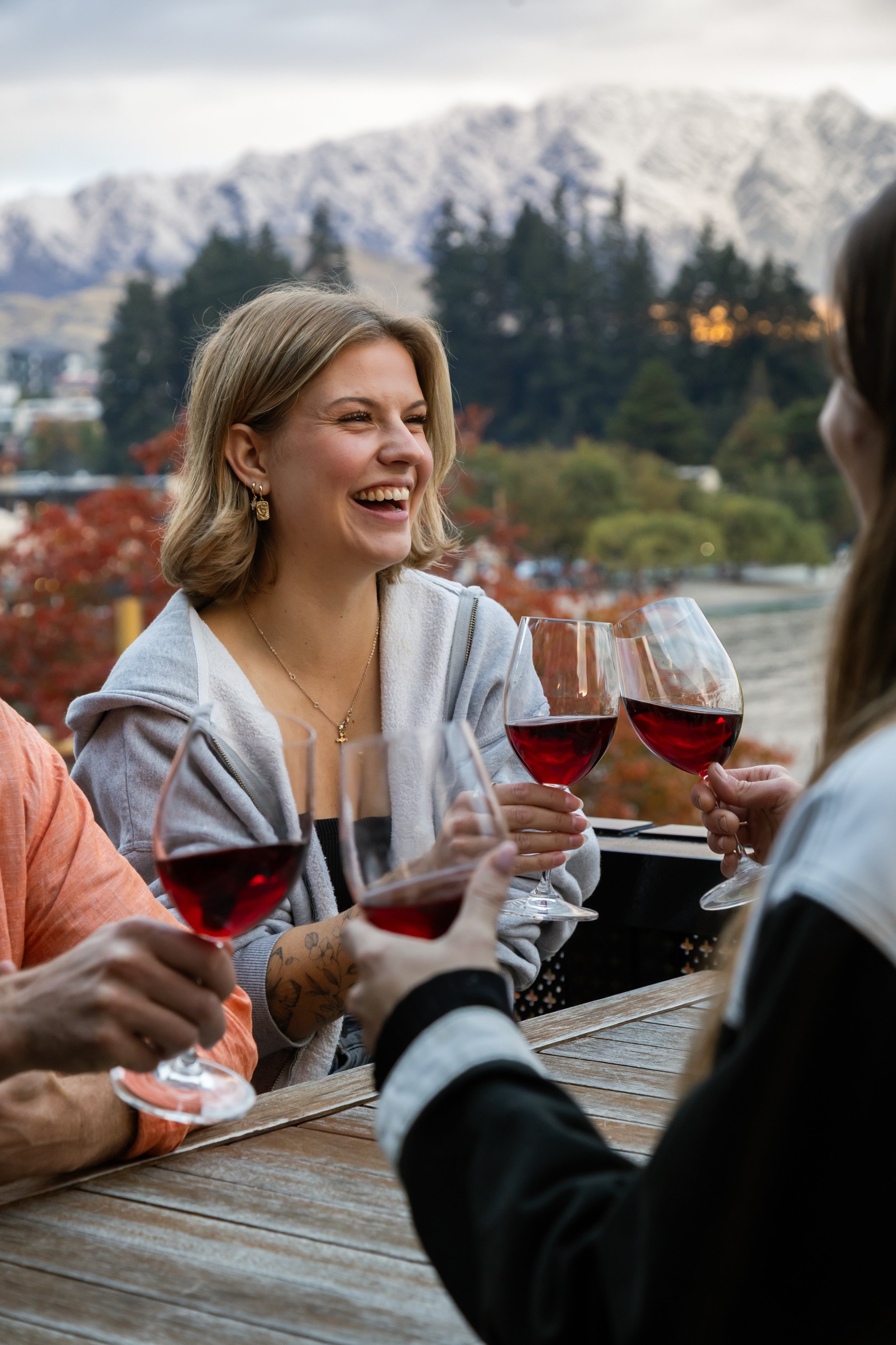 Mountain club member enjoying red wine in front of Remarkables mountain