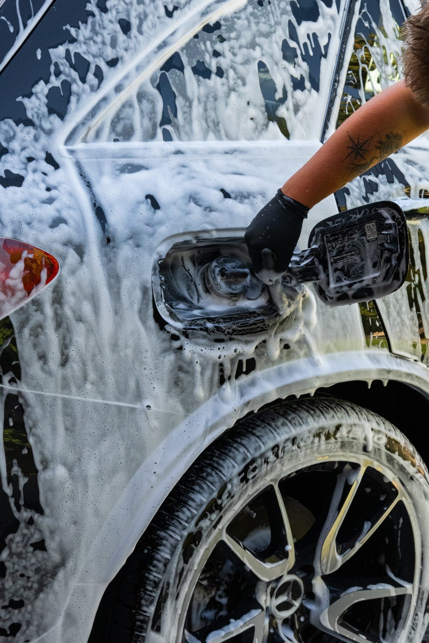 Foam covering a wheel and fuel door during a hand wash