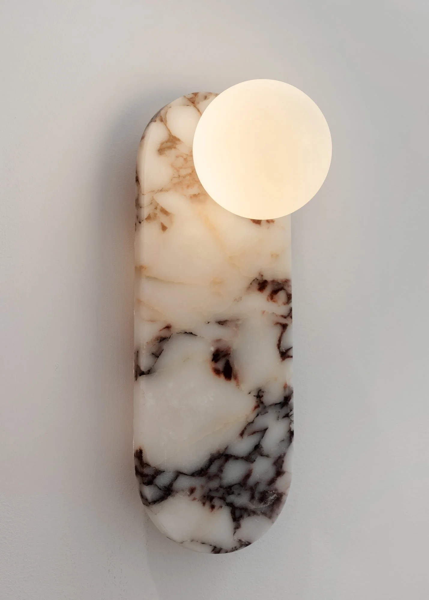 Marble-patterned jewelry piece with a glowing circular light at the top, set against a plain background.