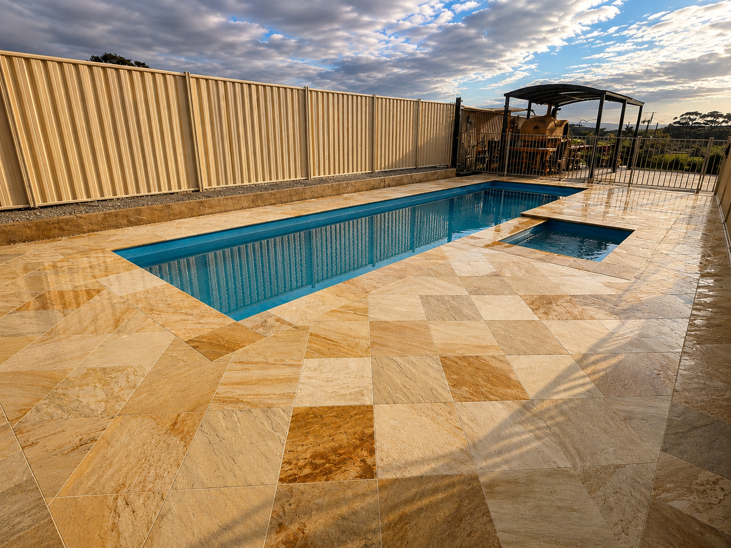 Swimming pool and spa surrounded by sandstone paving and landscaped outdoor area.