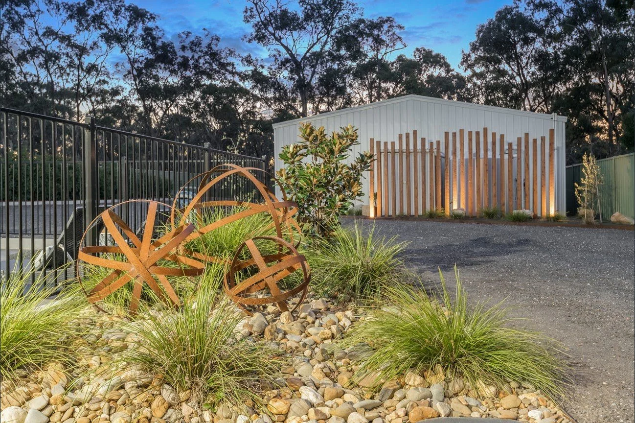 Landscaped garden with feature planting, gravel, decorative steel features and outdoor lighting.