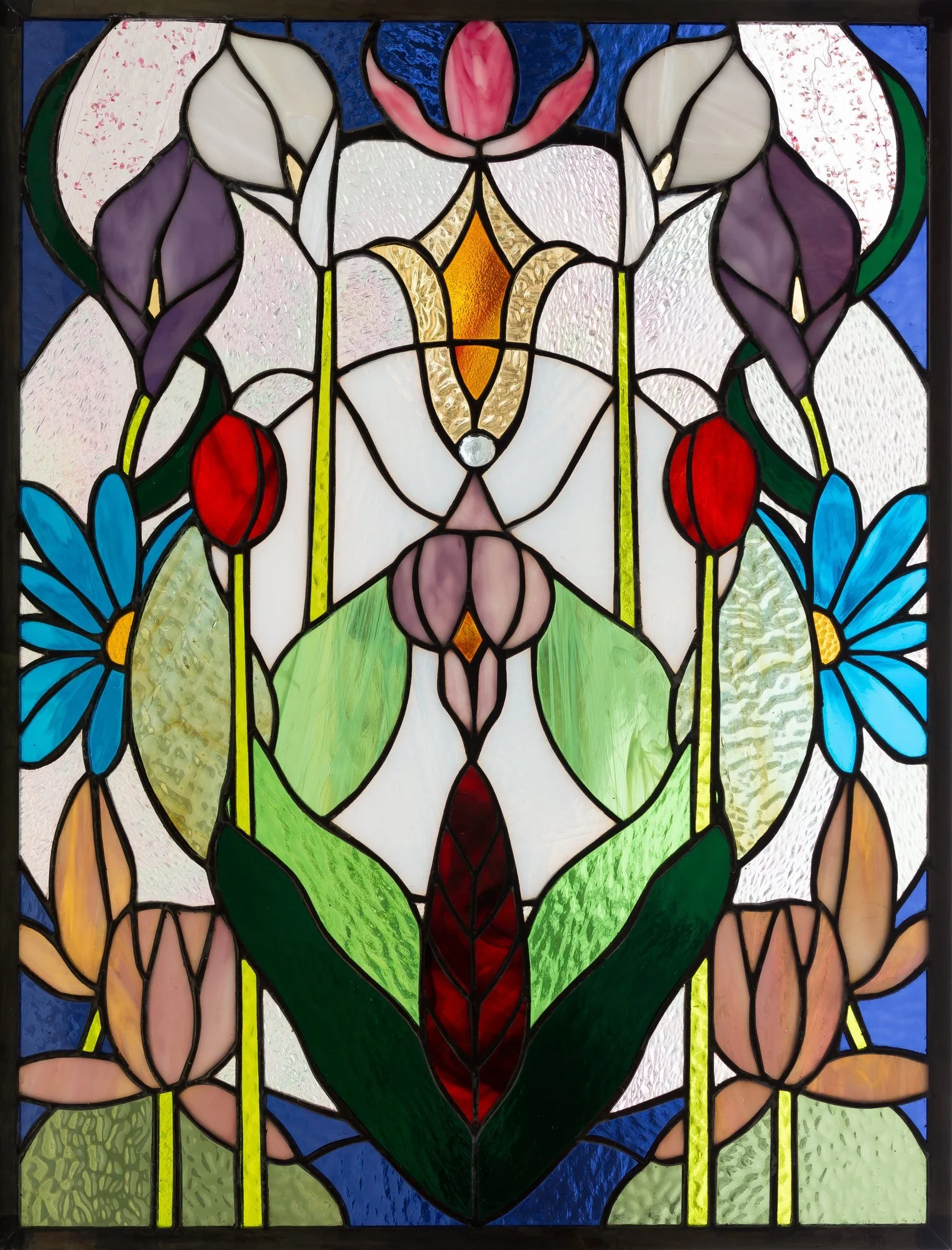 A symmetrical stained-glass floral design with purple, blue, red, green, and pale pink glass.
