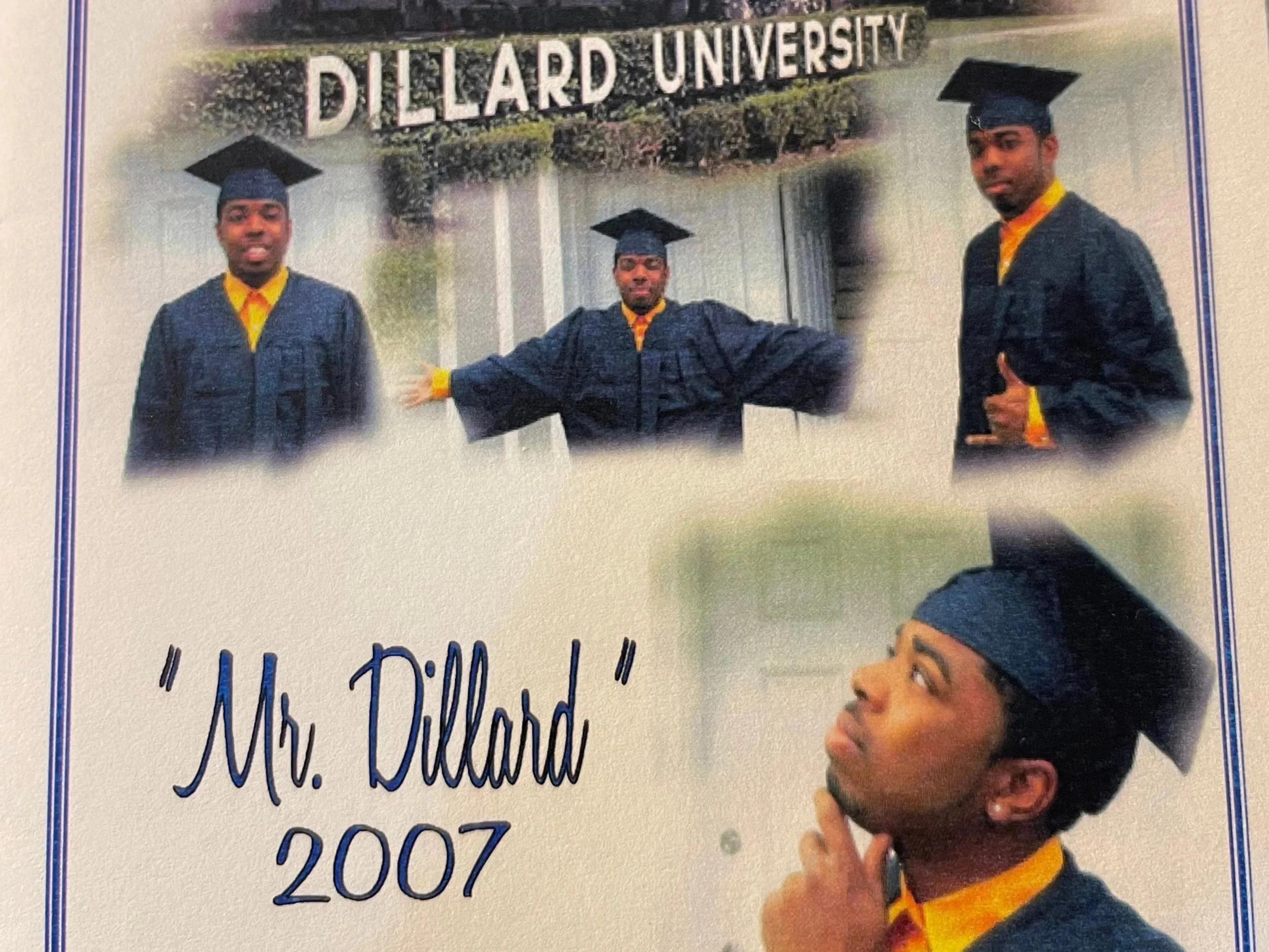 A young man in a black graduation gown and cap with a yellow shirt underneath is posing in front of a sign that reads "Dillard University." He has his arm extended outward and has his other hand on the side of his face, with a serious expression.