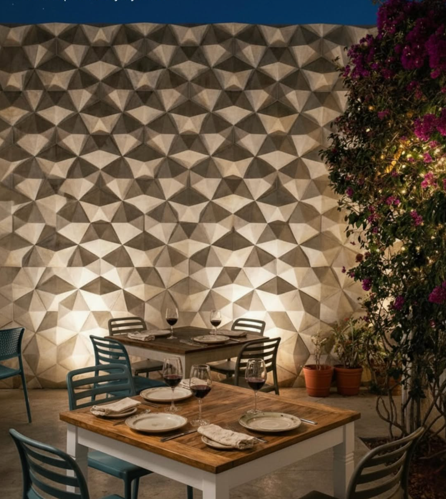 Indoor dining area with a decorated wall, a table set with plates, glasses of red wine, and silverware, surrounded by chairs, and potted plants.