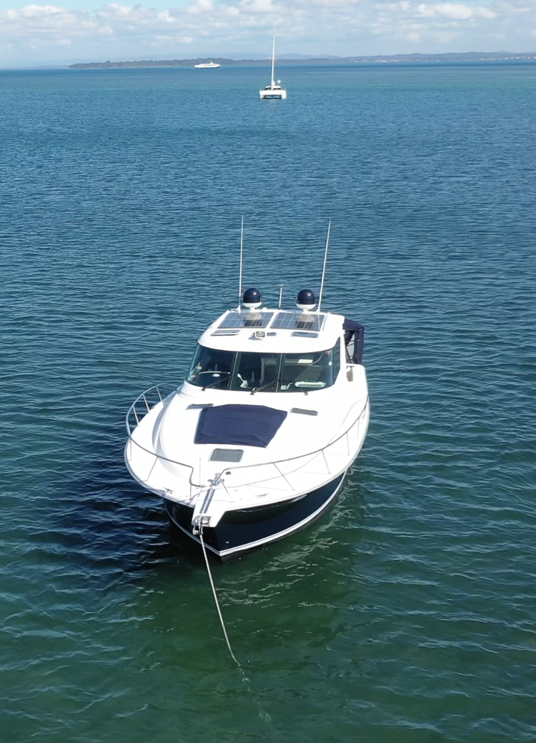 A white yacht anchored in calm blue water