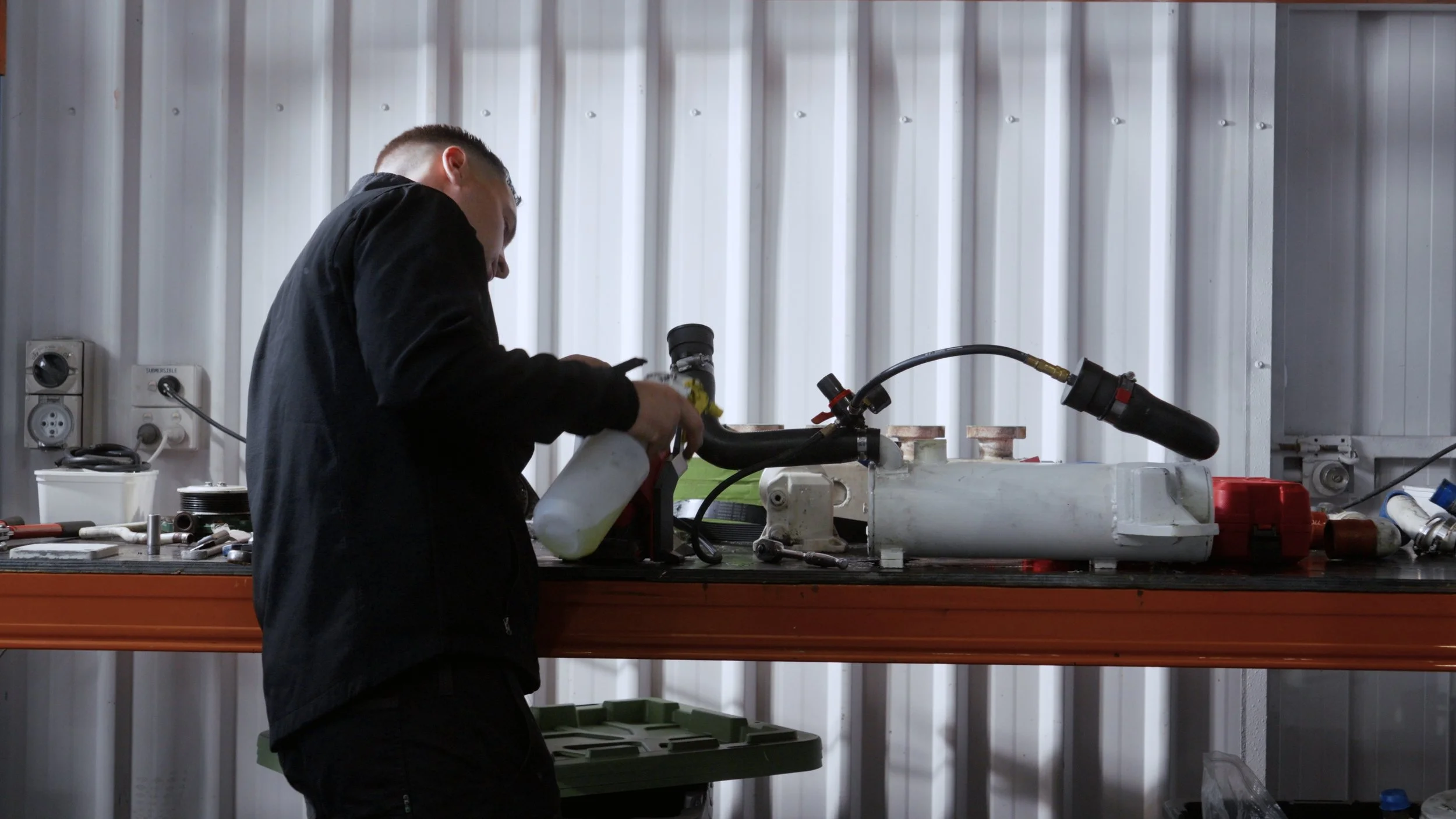 D’Aprix Marine Services team working with tools and equipment at a workbench in a workshop