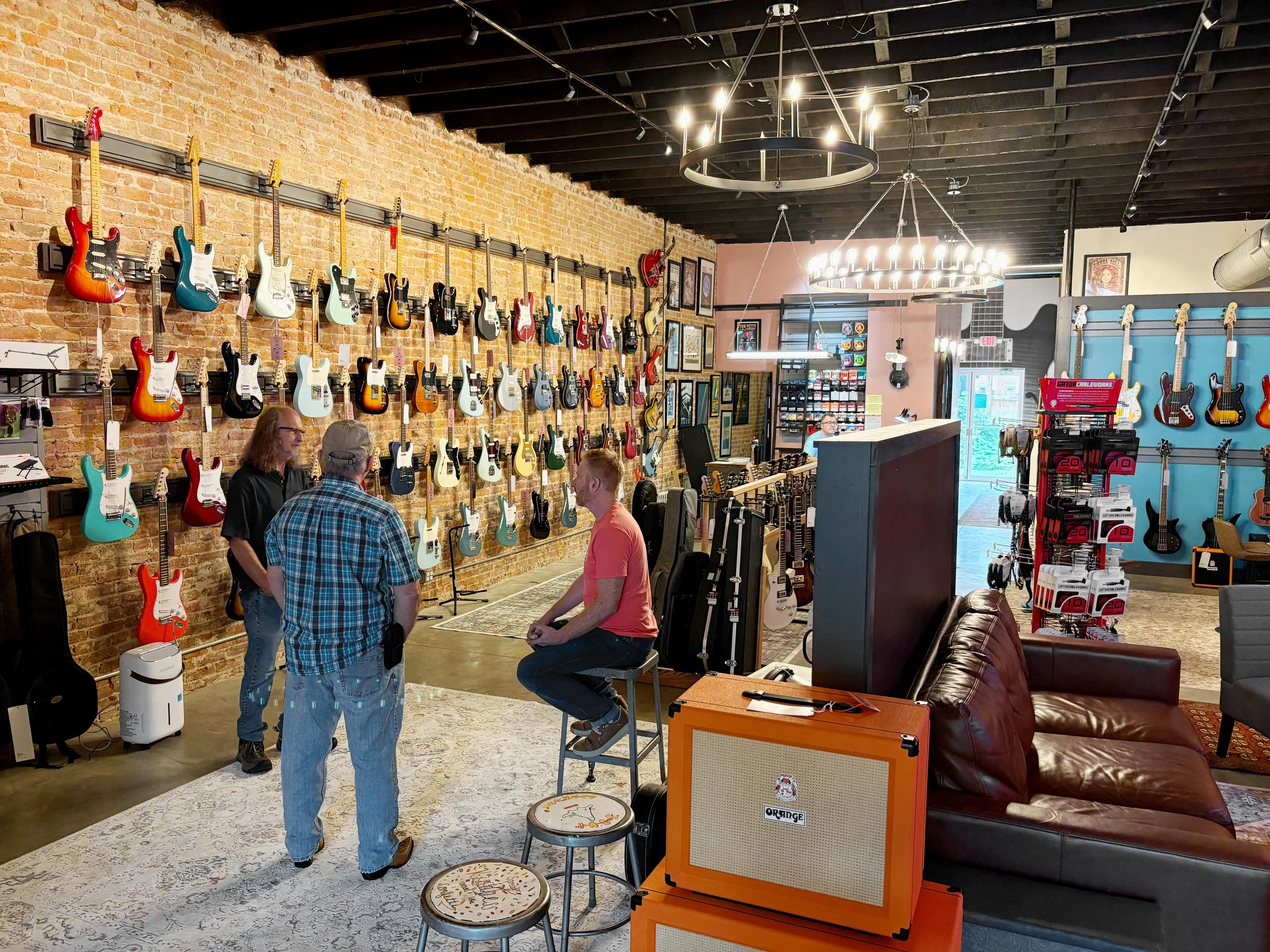 Frets Music Shop: Campbellsville, Kentucky. Wall of guitars inside warm music store.