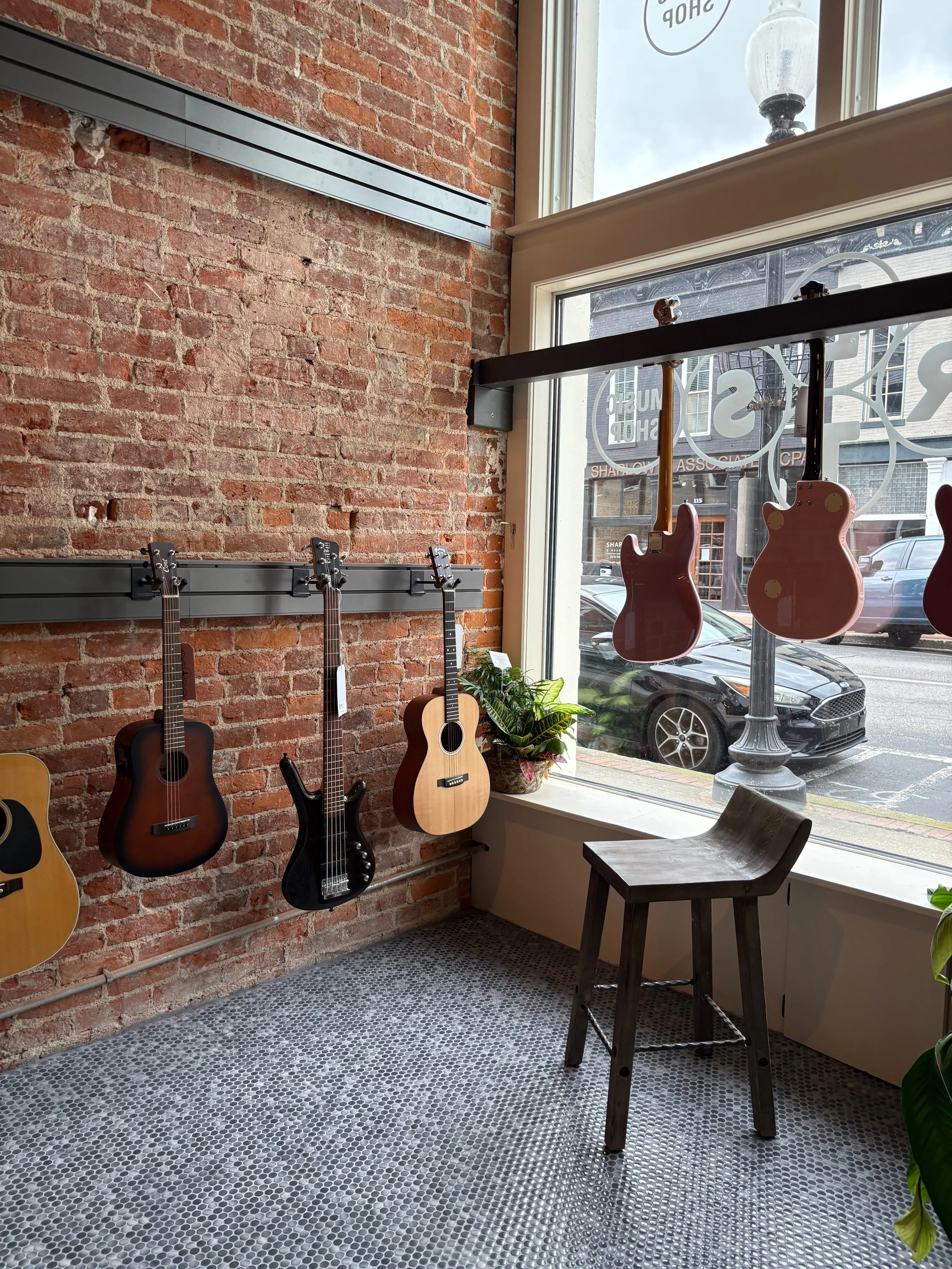 Frets Music Shop: Campbellsville, Kentucky. Guitars hanging on the wall of a warm, light space