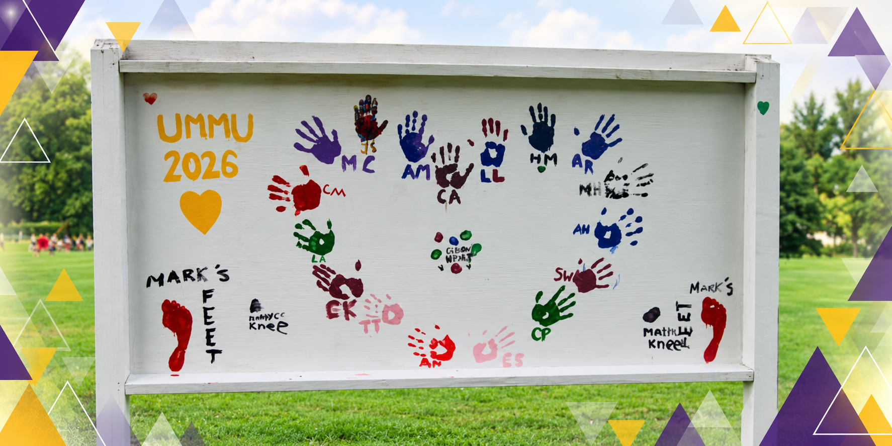 Whiteboard with colorful handprints, initials, and names to celebrate a graduation event in a park. Text includes "UMMU 2026" with a yellow heart, and various handprints labeled with initials and full names, such as "MC," "AM," "LA," and others. The background shows trees and a grassy field.