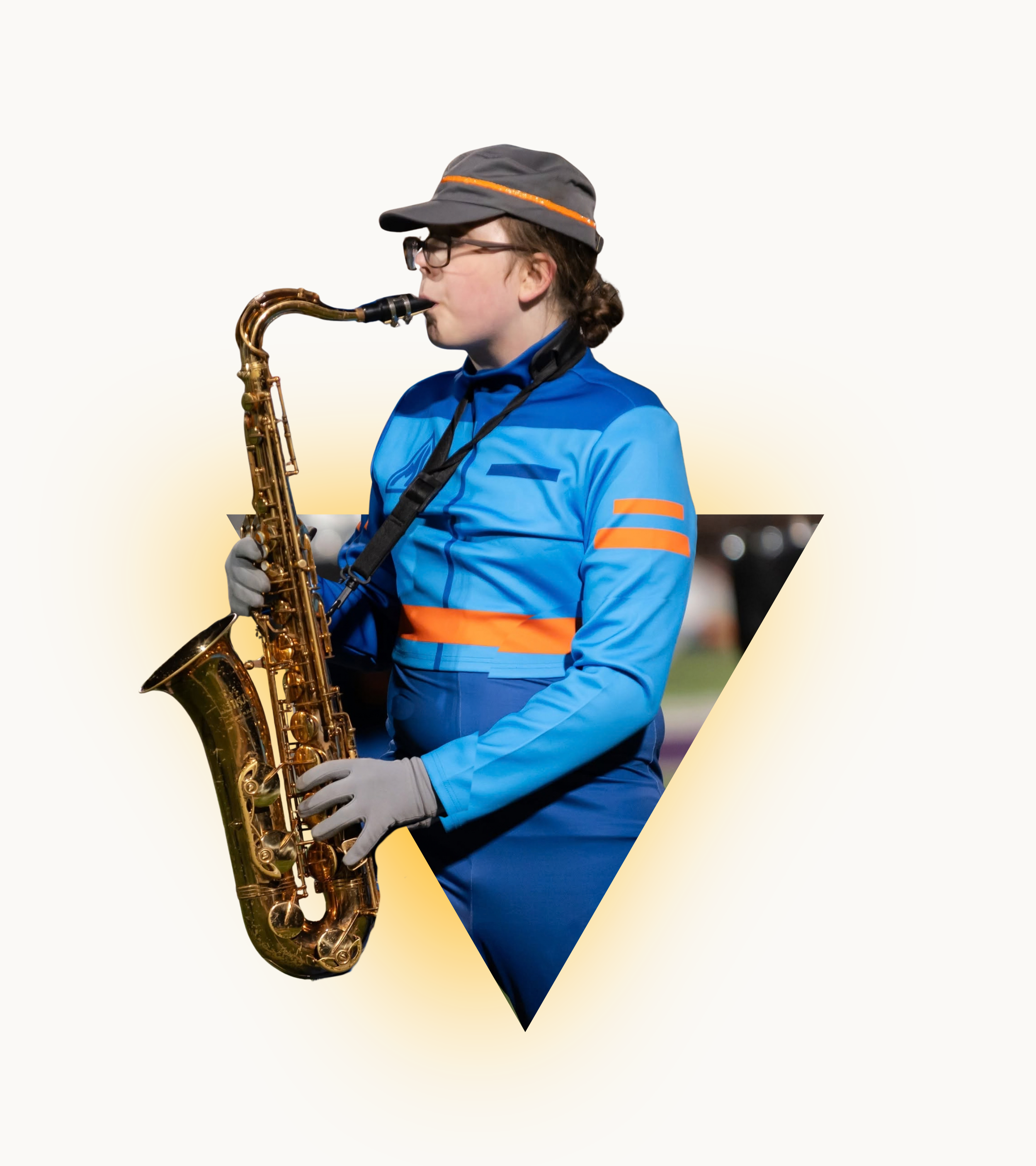 Young woman with glasses wearing a gray cap and blue jacket playing a brown saxophone outdoors at night.