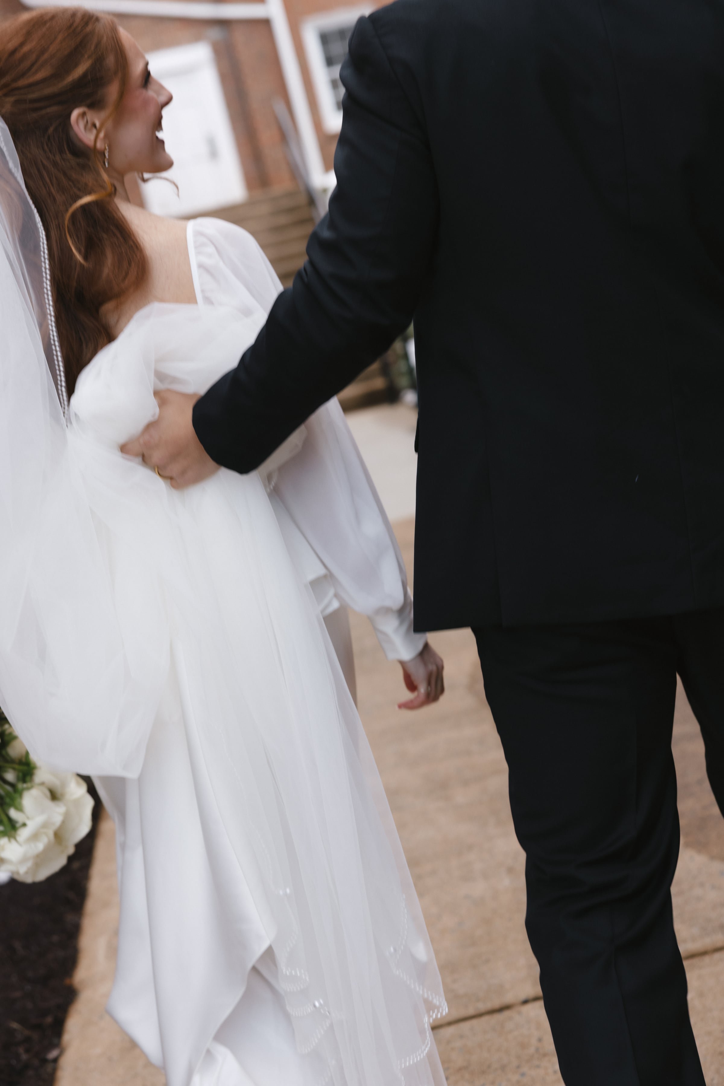 Bride and groom holding hands during their wedding ceremony outdoors.