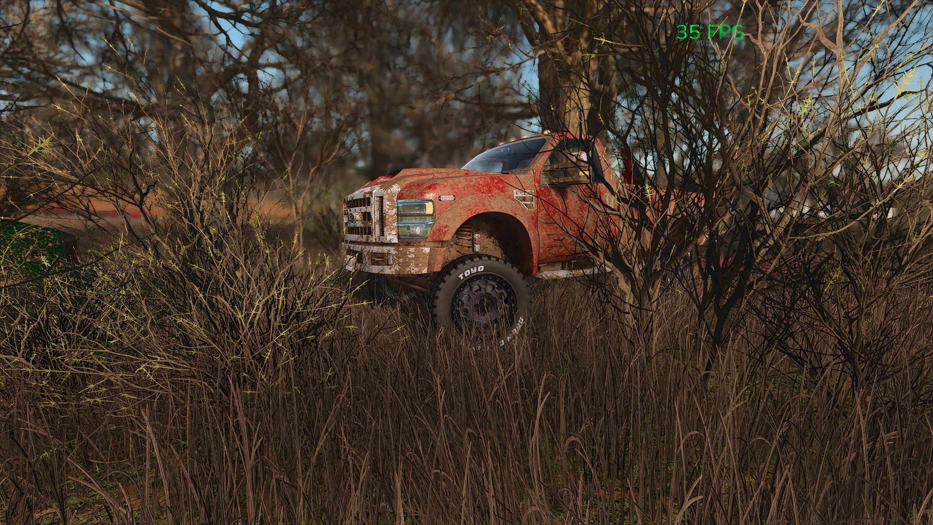 A dirt-covered red pickup truck parked behind tall grass and leafless trees, with a blue sky background, and a green FPS counter in the top right corner.