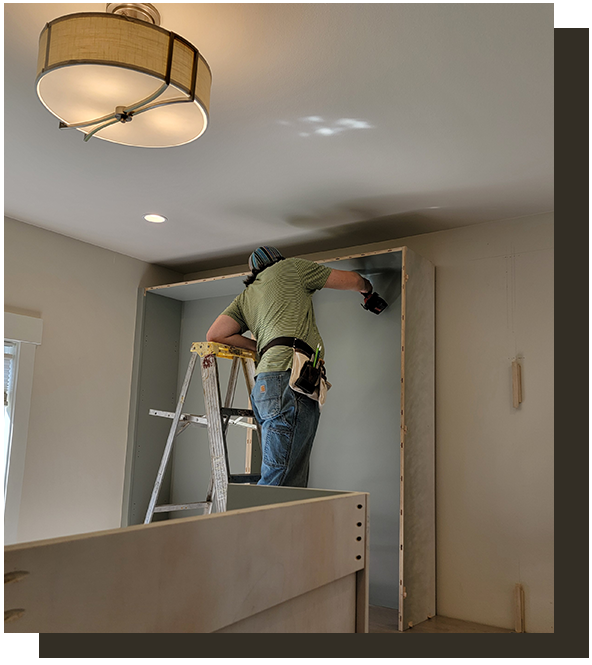 Worker installing custom cabinetry in Kitsap County