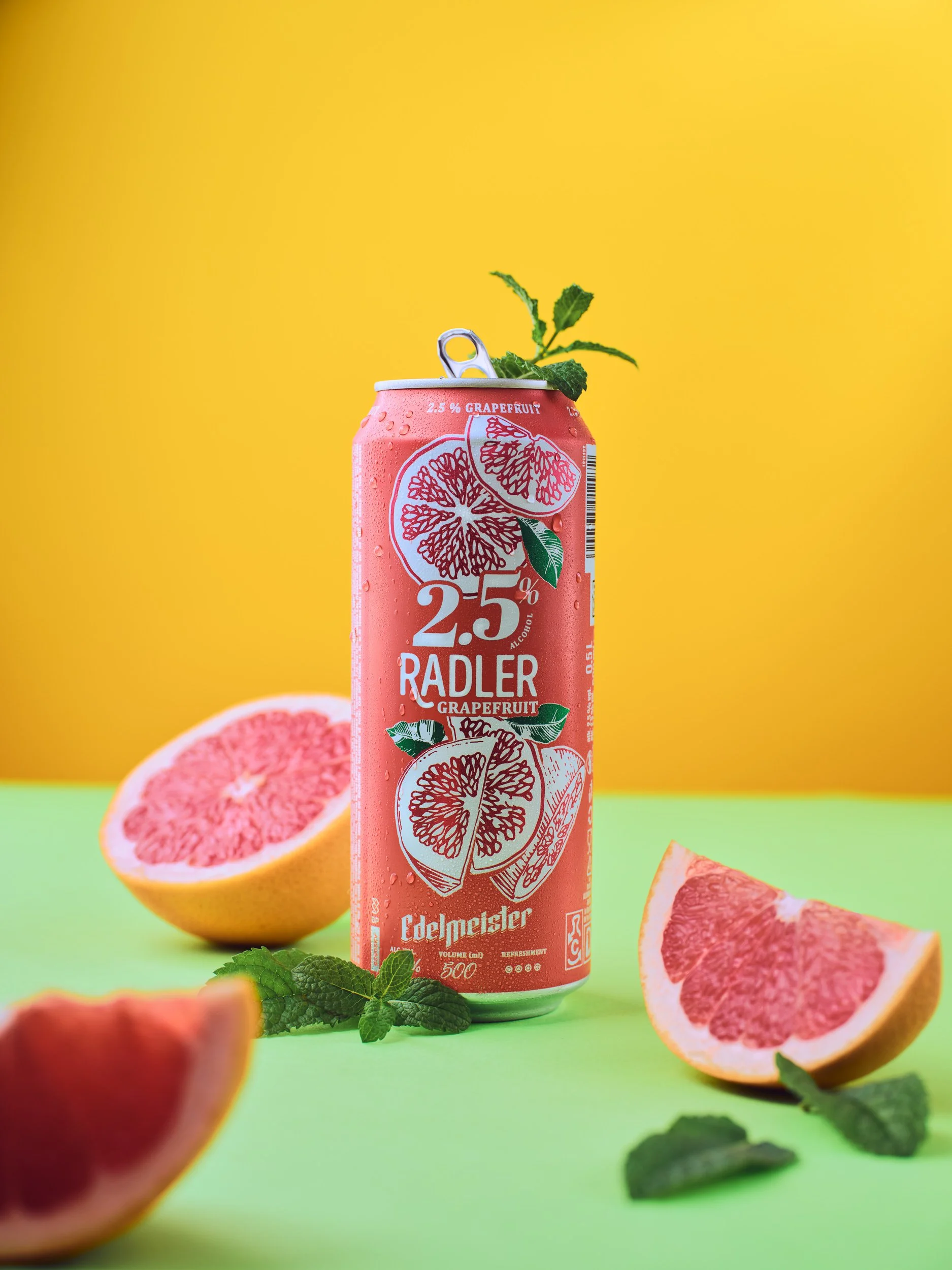 Commercial beverage and product photography of a grapefruit radler can styled with fresh grapefruit and mint, created for drink brands, packaging and advertising campaigns