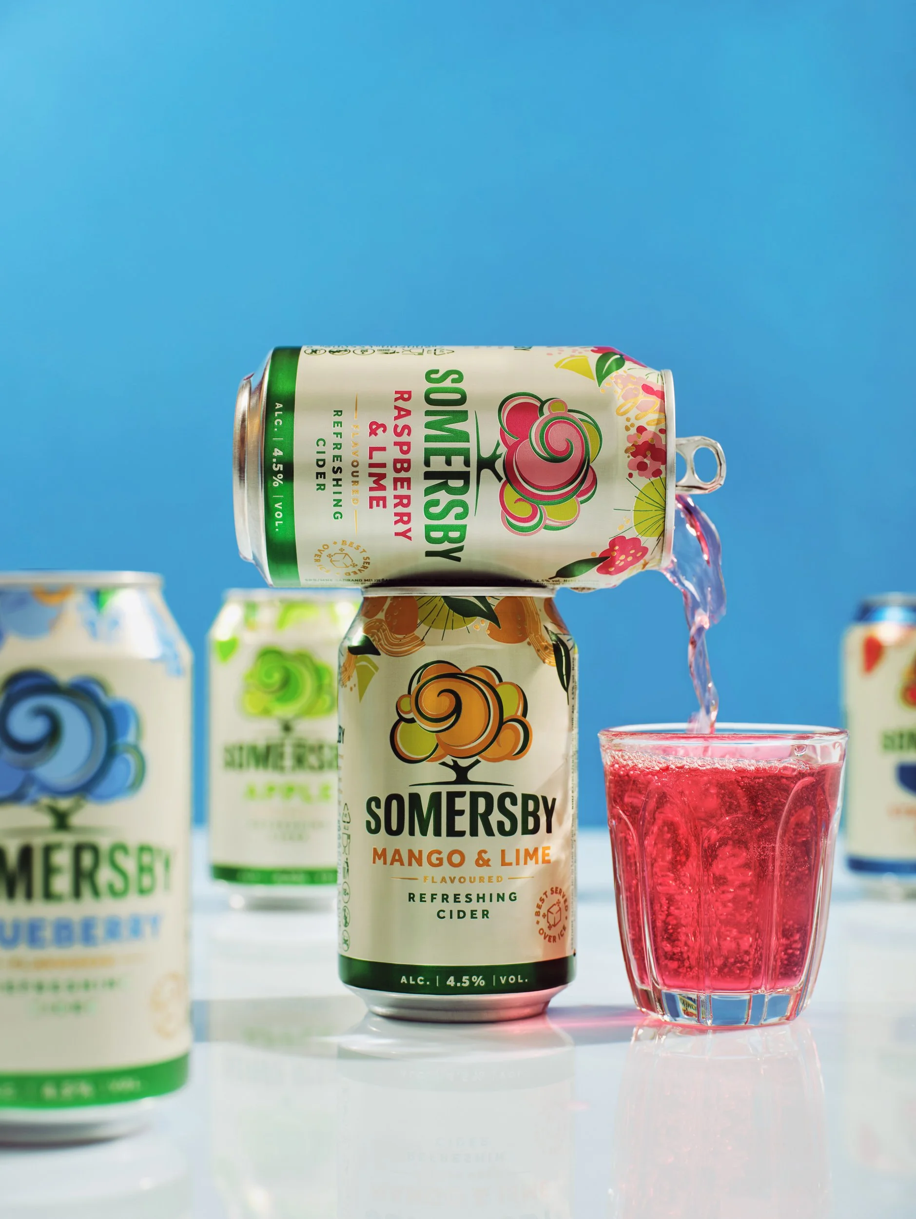 Commercial product photography of Somersby fruit cider, featuring Raspberry & Lime and Mango & Lime cans with a dynamic drink pour, styled for beverage advertising and social media campaigns