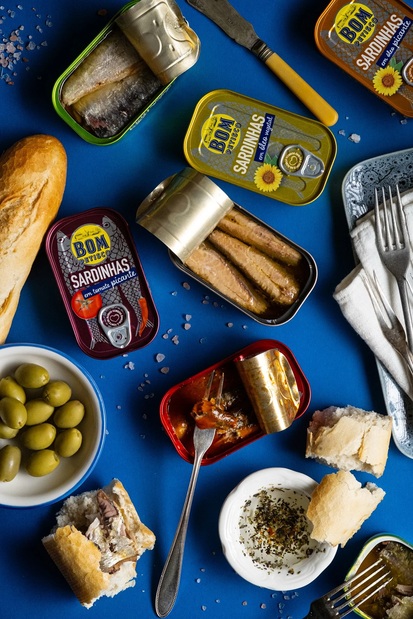Commercial product photography and food styling of canned sardines with bread and olives, created for food brands, packaging, e-commerce and advertising campaigns