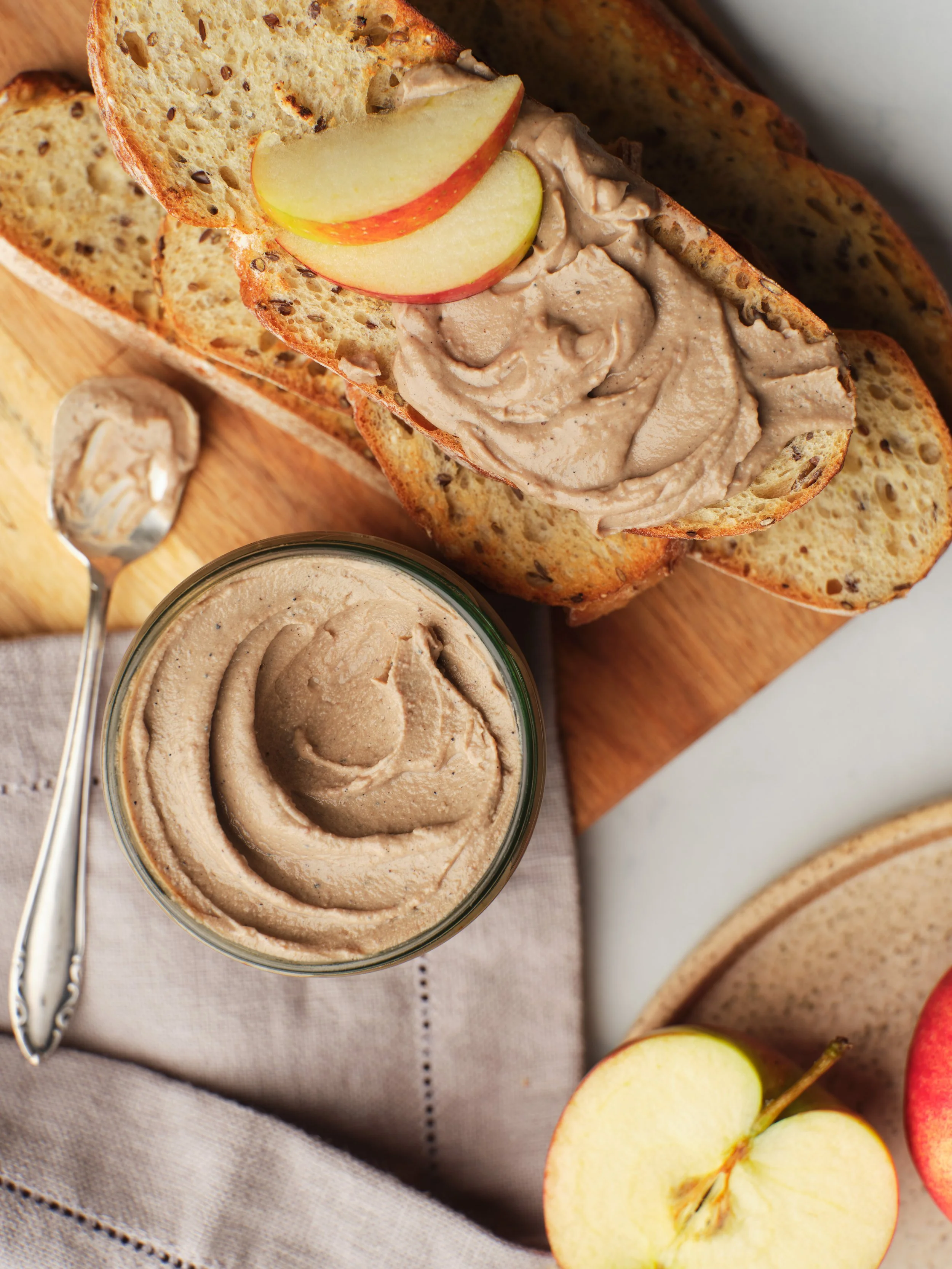 Creamy chicken liver pâté served with crisp toasted bread and fresh apple slices, photographed in a warm rustic food setting