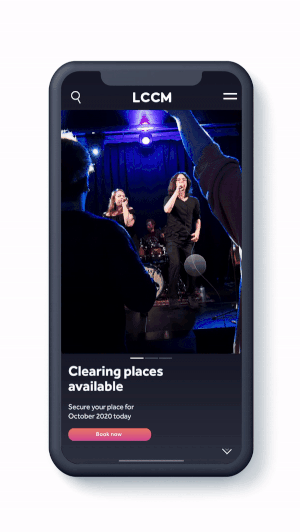 Mobile phone displaying a live performance or karaoke event with two women singing on stage, surrounded by an audience in a dimly lit venue.