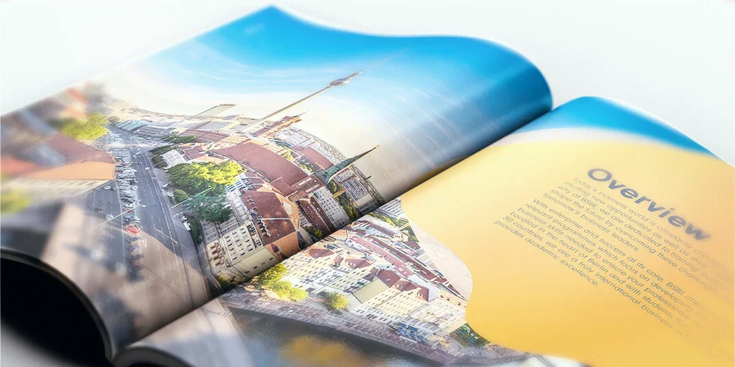 Open magazine featuring a cityscape with historic buildings and a prominent church steeple on a sunny day.