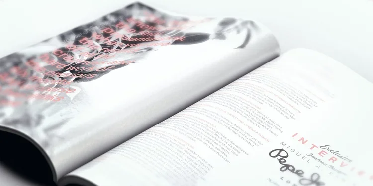 An open magazine featuring a black and white photograph and pink and black text on the pages.