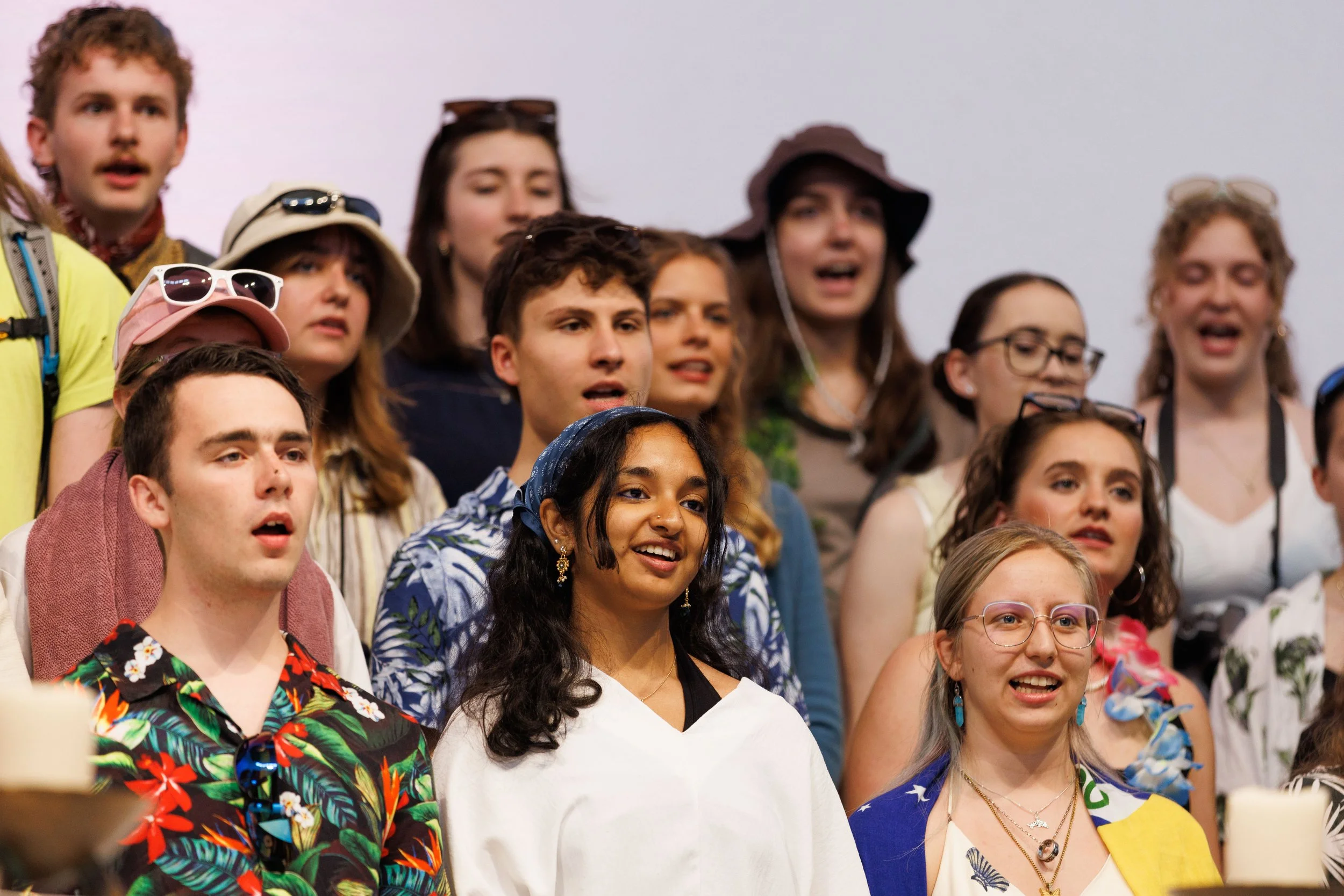 Gruppe junger Menschen beim Singen oder Singen auf einer Veranstaltung, mit fröhlicher Stimmung.