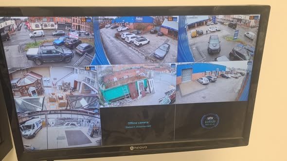 Security monitor displaying multiple surveillance camera feeds of parking lots and streets.