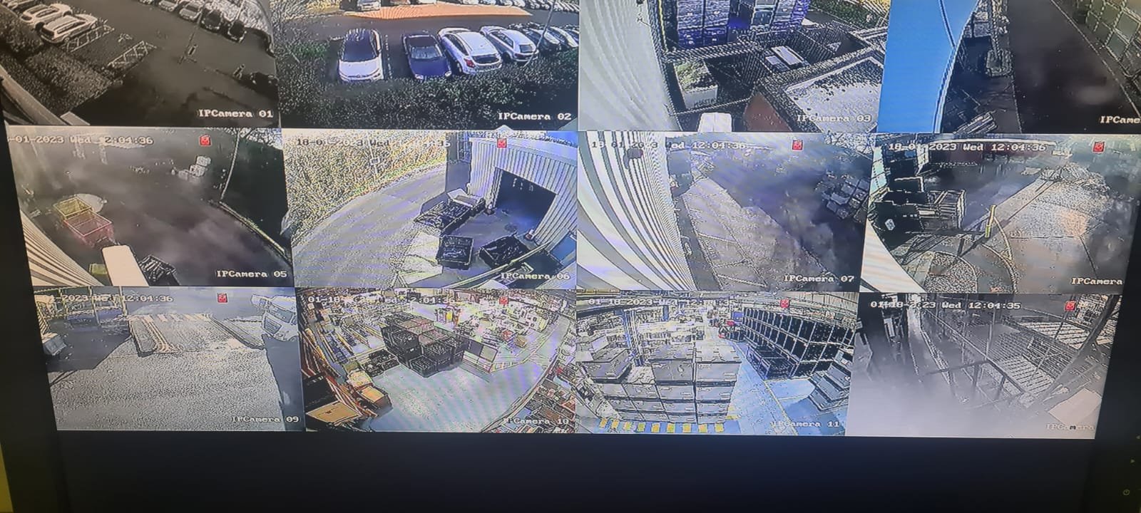 Security camera feeds showing various outdoor and indoor scenes, including parking lots, a loading dock, and storage areas.