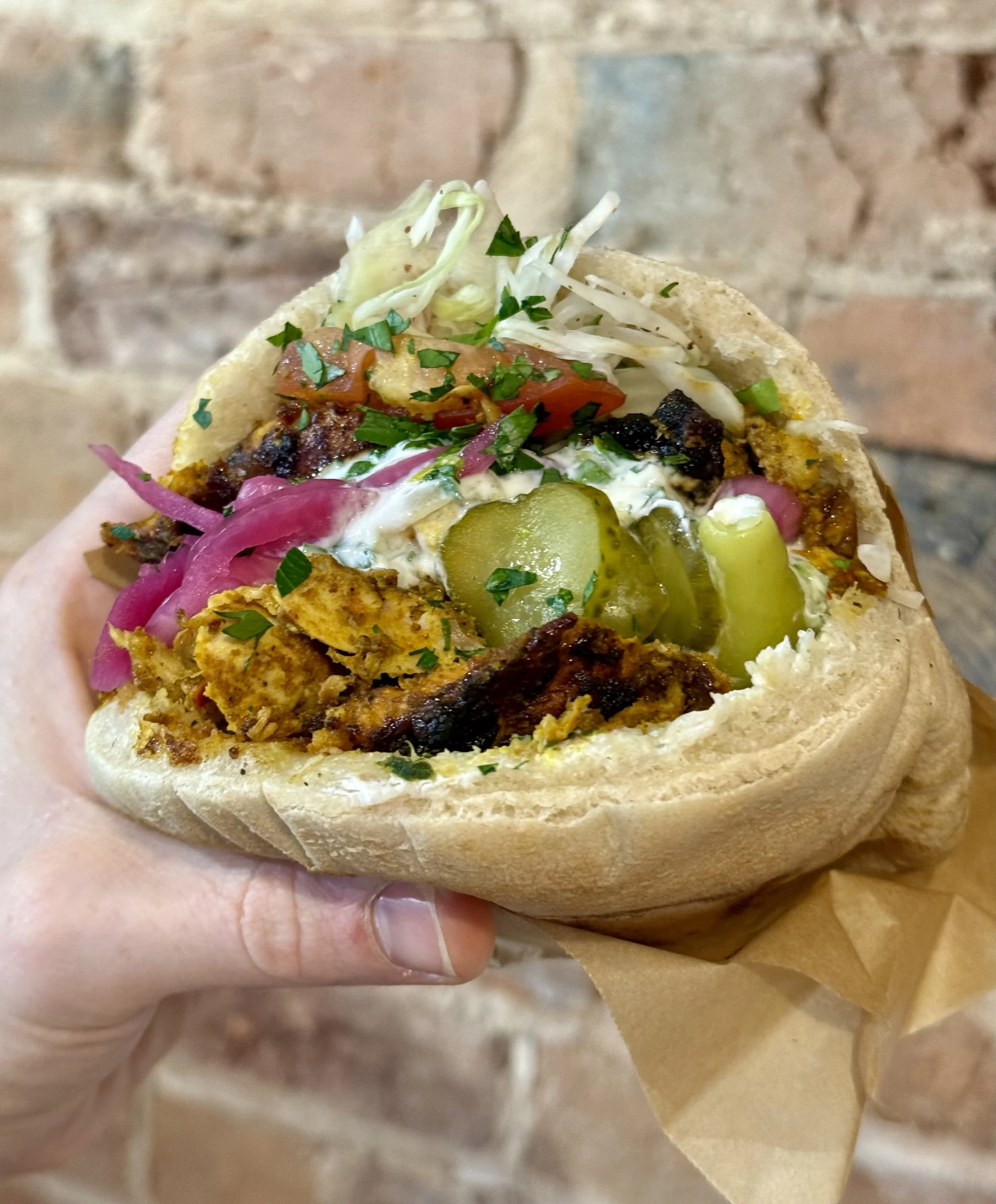 Chicken shawarma pita with fresh salad, house pickles and sauces.