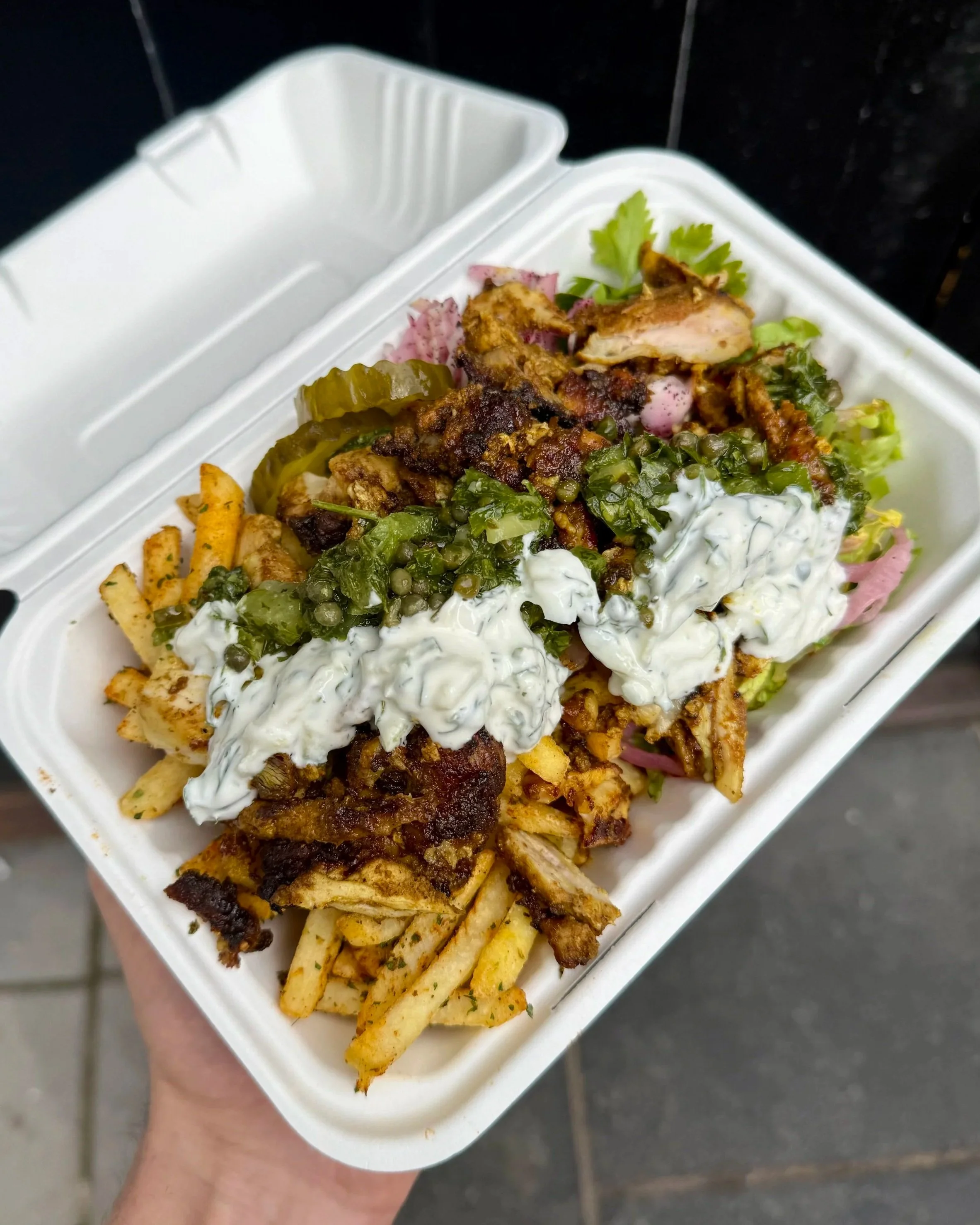Chicken shawarma box with seasoned fries, salad, house pickles and sauces.