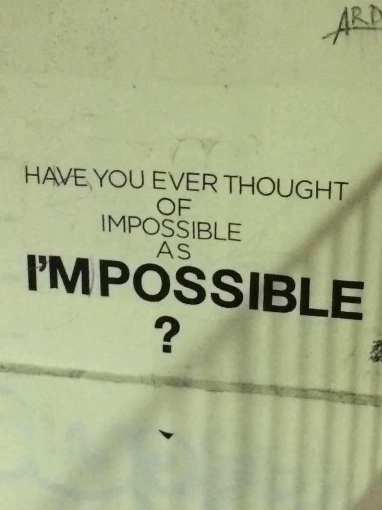 Inspirational quote on a wall asking if you have ever thought of impossible as impossible.