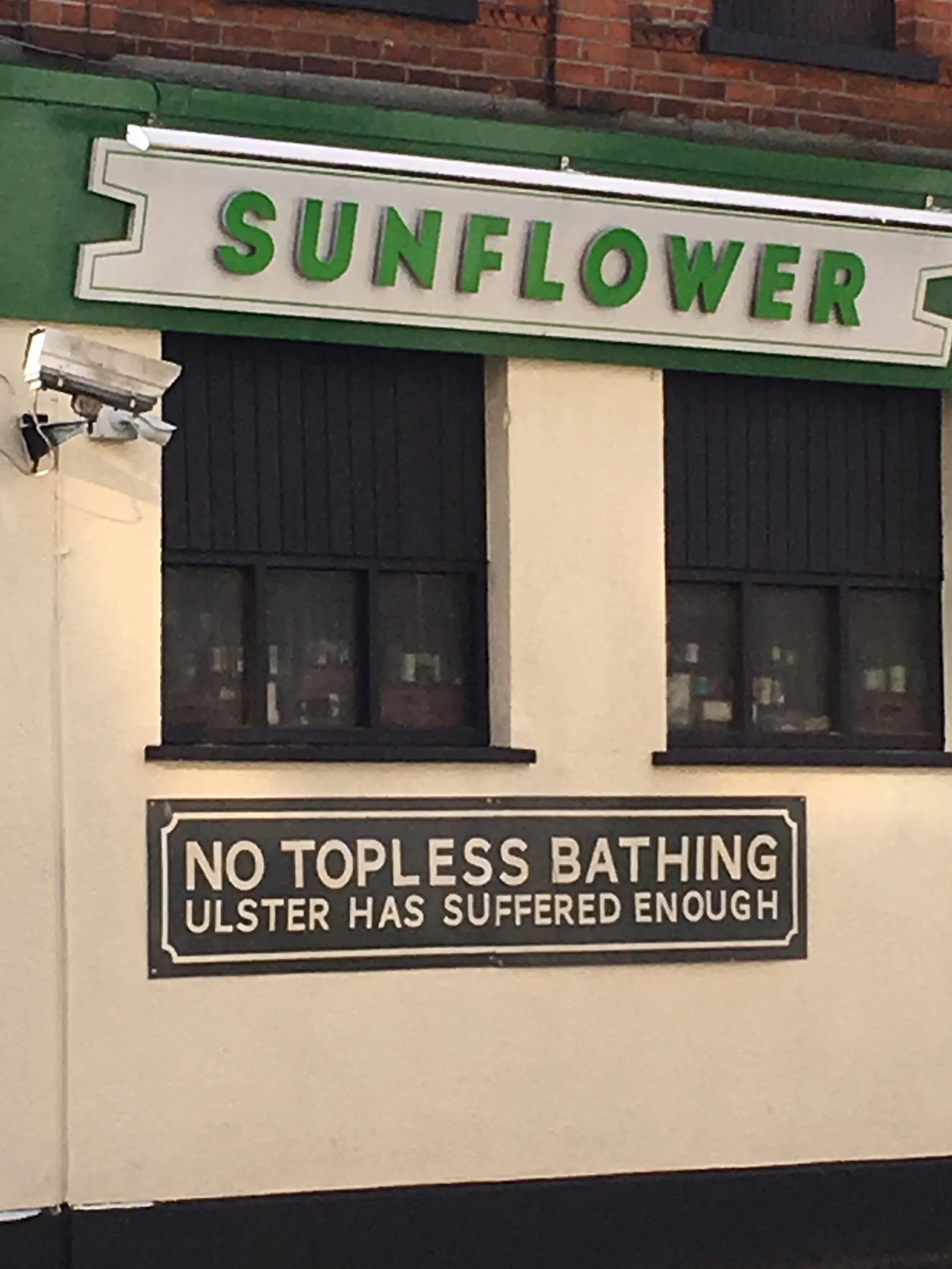 Sign with the word 'Sunflower' in green letters on a white background.