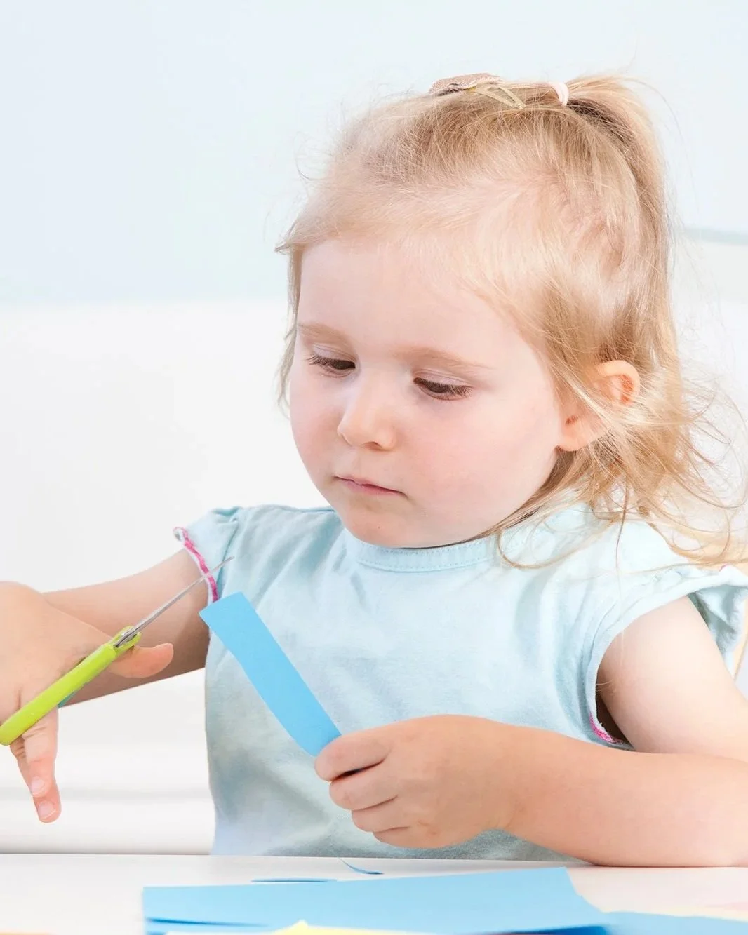 Une jeune fille blonde avec une queue de cheval reçoit une vaccination. Quelqu'un lui administre une injection dans le bras gauche.