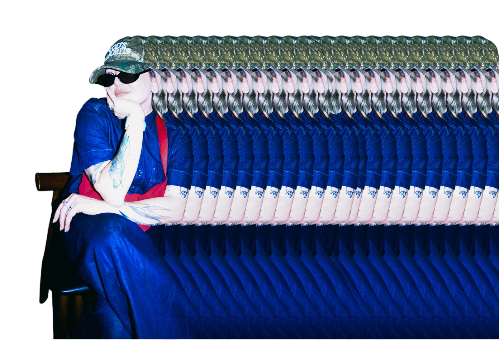 A woman sitting on a chair with multiple overlapping, distorted images of herself extending to the right. She is wearing sunglasses, a camouflage cap, a blue shirt, and has tattoos on her arms, with her left hand resting on her face.