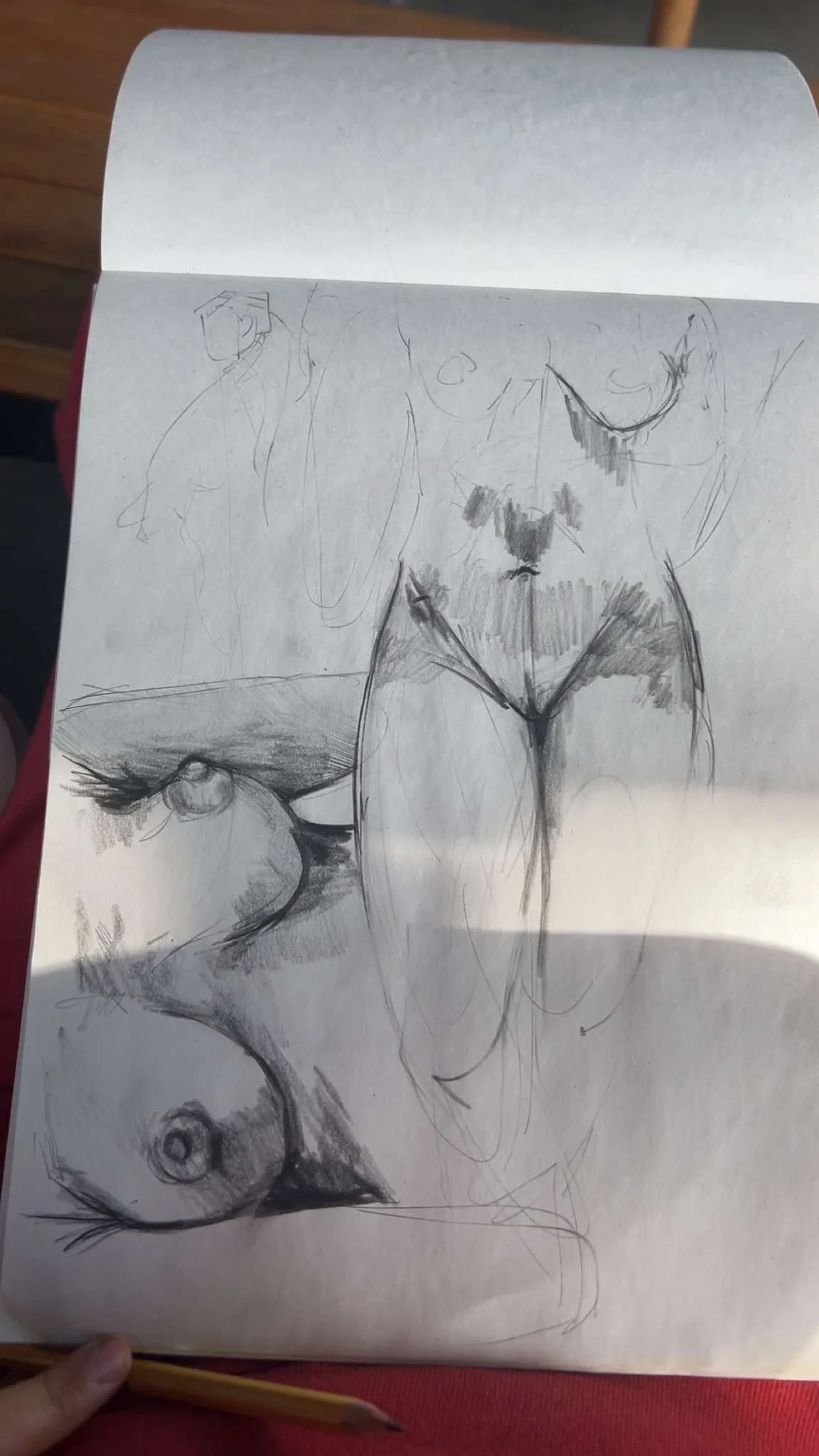 FIGURE STUDIES. Graphite in sketchbook. 9×12". A sketchbook page of graphite figure studies — torso and limb forms worked at several scales, some lightly indicated, others modeled with hatching. Drawn from life.