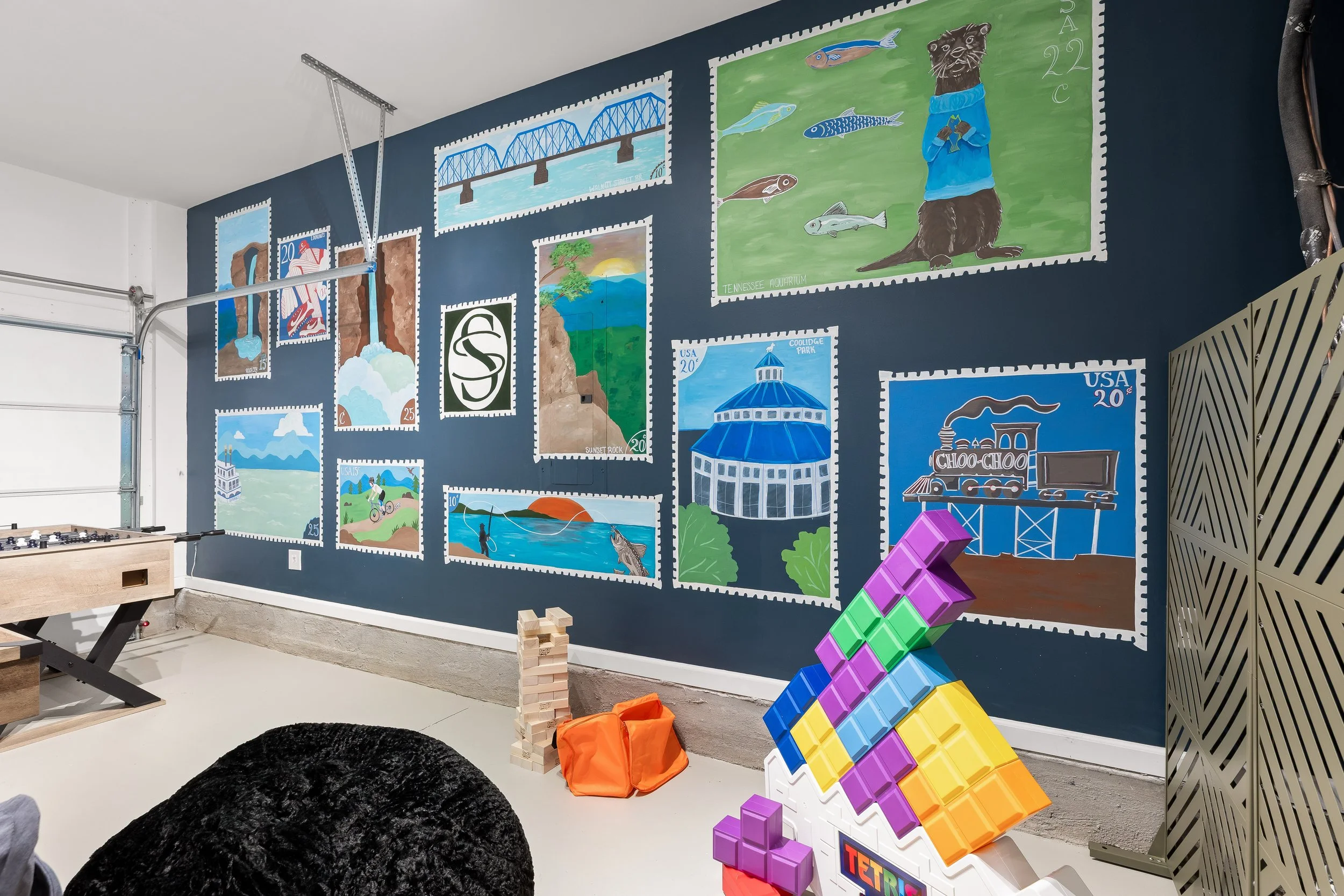 Family-friendly game room with air hockey, games and colorful Chattanooga-inspired artwork at Summit & Stone vacation rental.