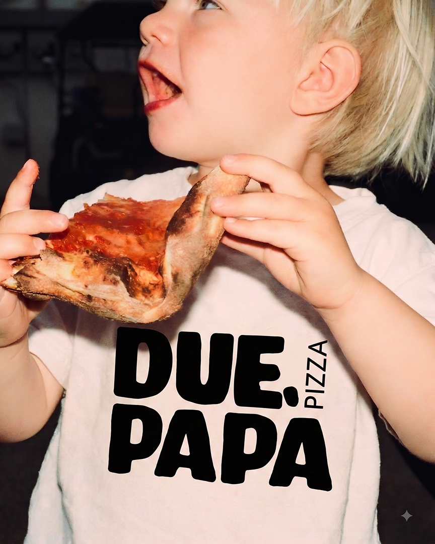 En ung pojke som äter en stor skiva pizza.