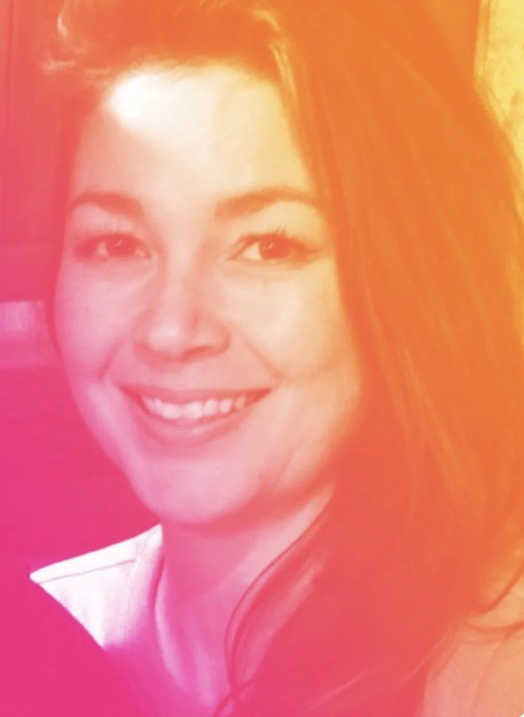Close-up portrait of a woman with long red hair, smiling, with a pink and orange gradient overlay.