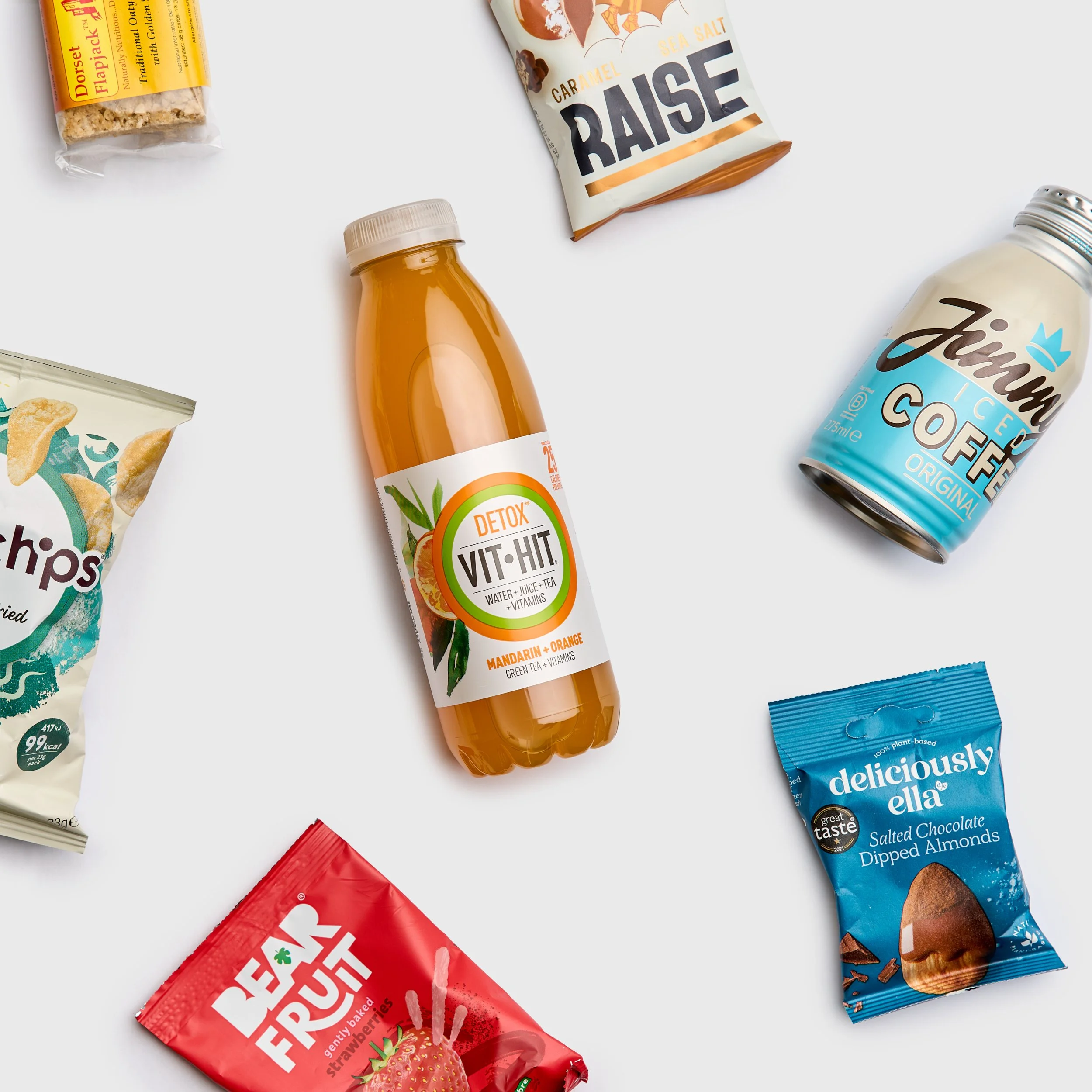 Assorted snack items including a bag of popchips, a bottle of orange vithit, a package of salted chocolate almonds, jimmys coffee