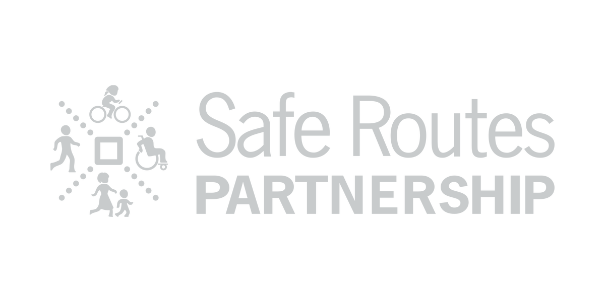 Logo for Safe Routes Partnership, featuring icons of children walking and riding bikes connected in a circle around a square, with the organization's name.