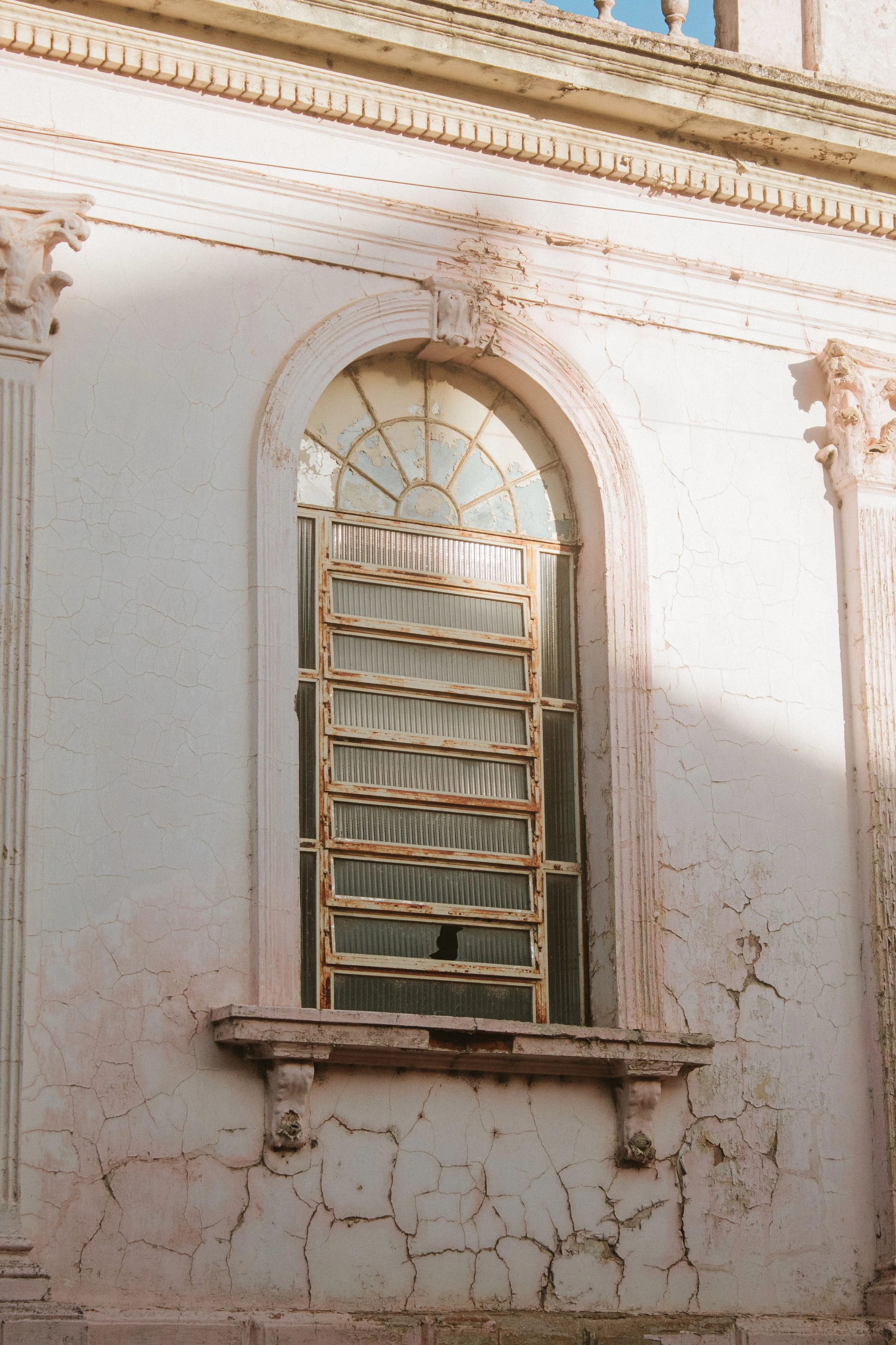 Faïençage et fissuration sur façade, bâtiment ancien en pierre.