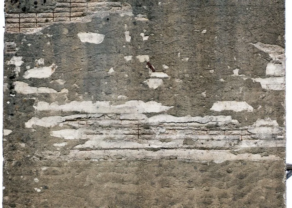 Mur béton armé avec aciers oxydés apparents, présence d'éclats de béton.